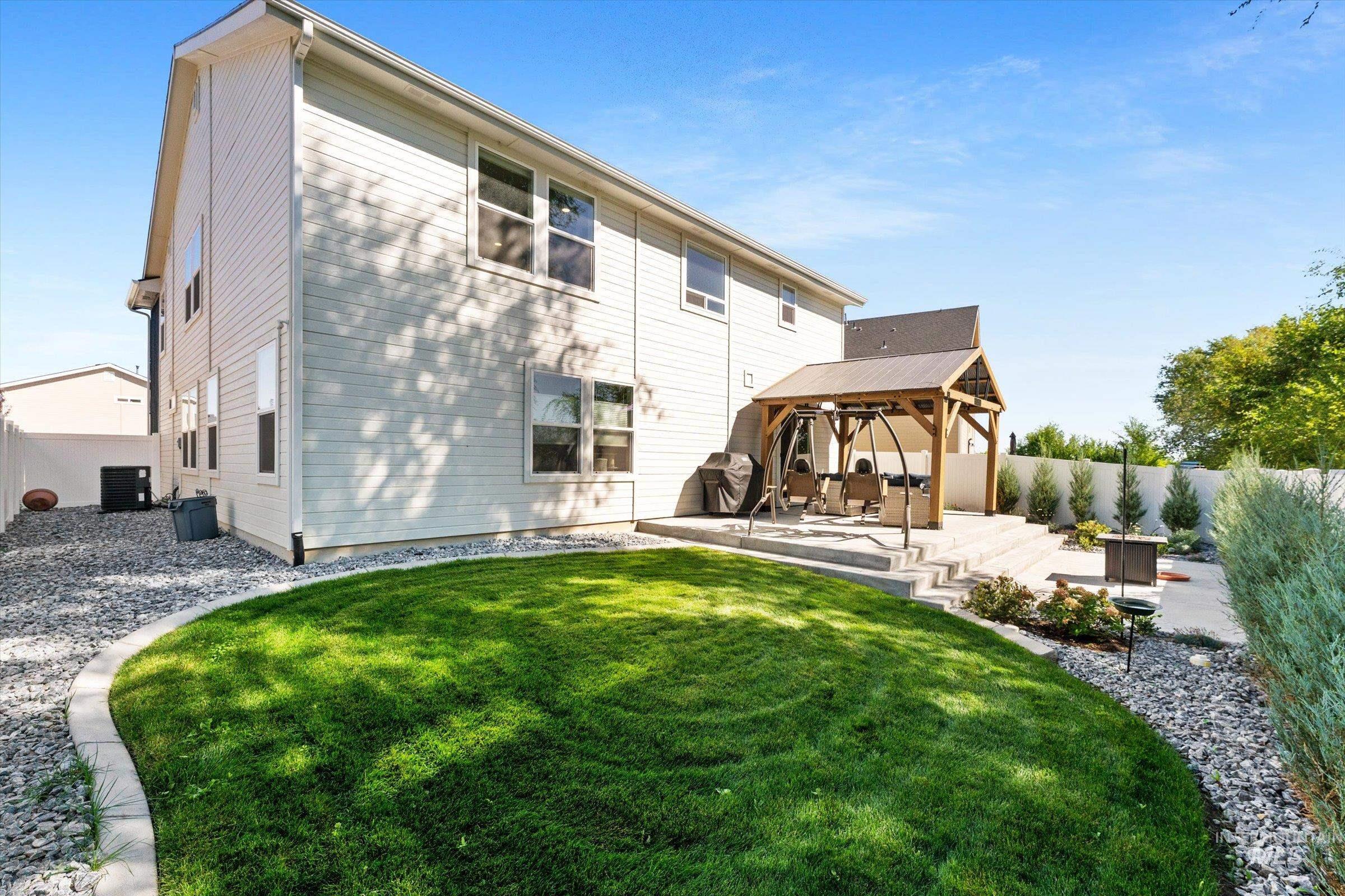 Back of property featuring a gazebo and a patio area