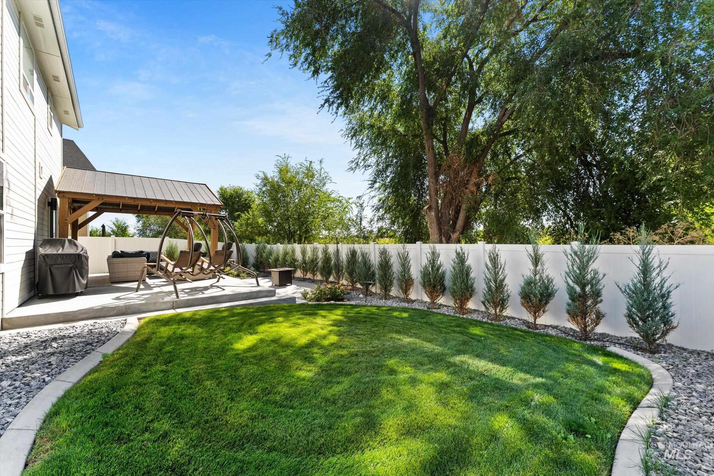 Fenced backyard with newly planted privacy trees.