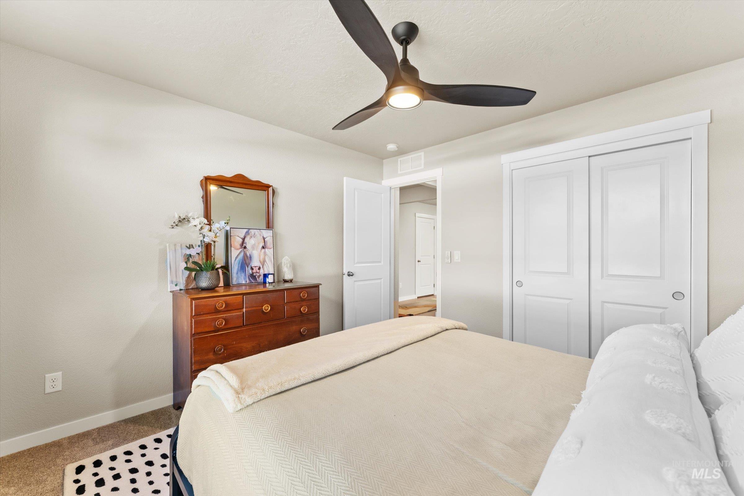 Bedroom featuring ceiling fan, a closet, and carpet flooring