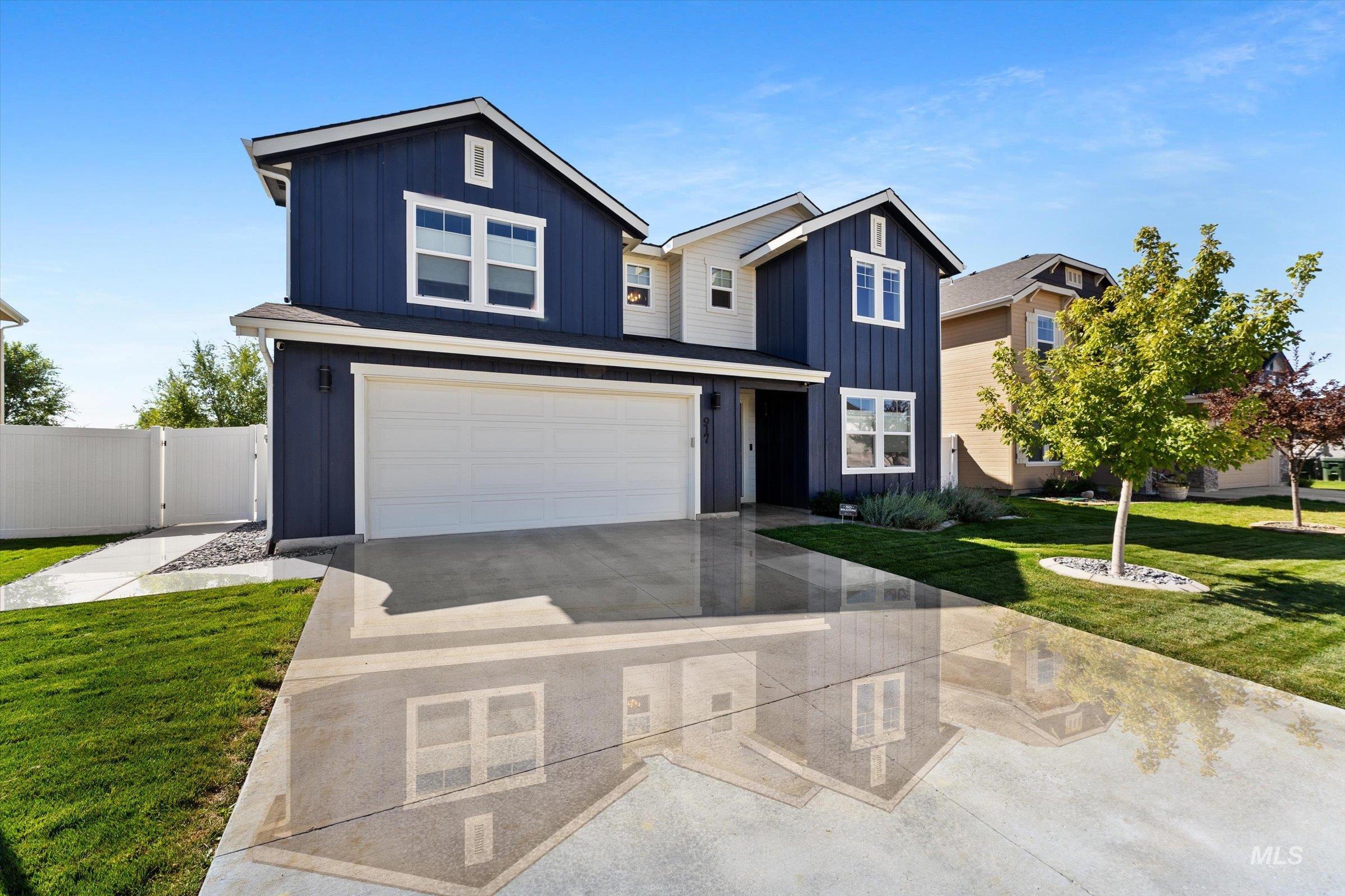 View of front of home featuring board and batten siding, driveway, and a garage