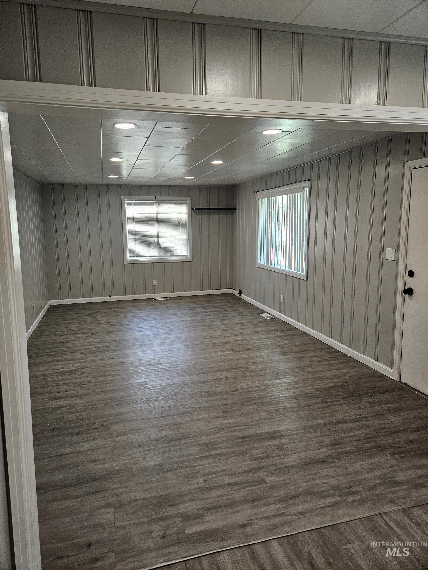 Empty room featuring dark wood-type flooring and recessed lighting
