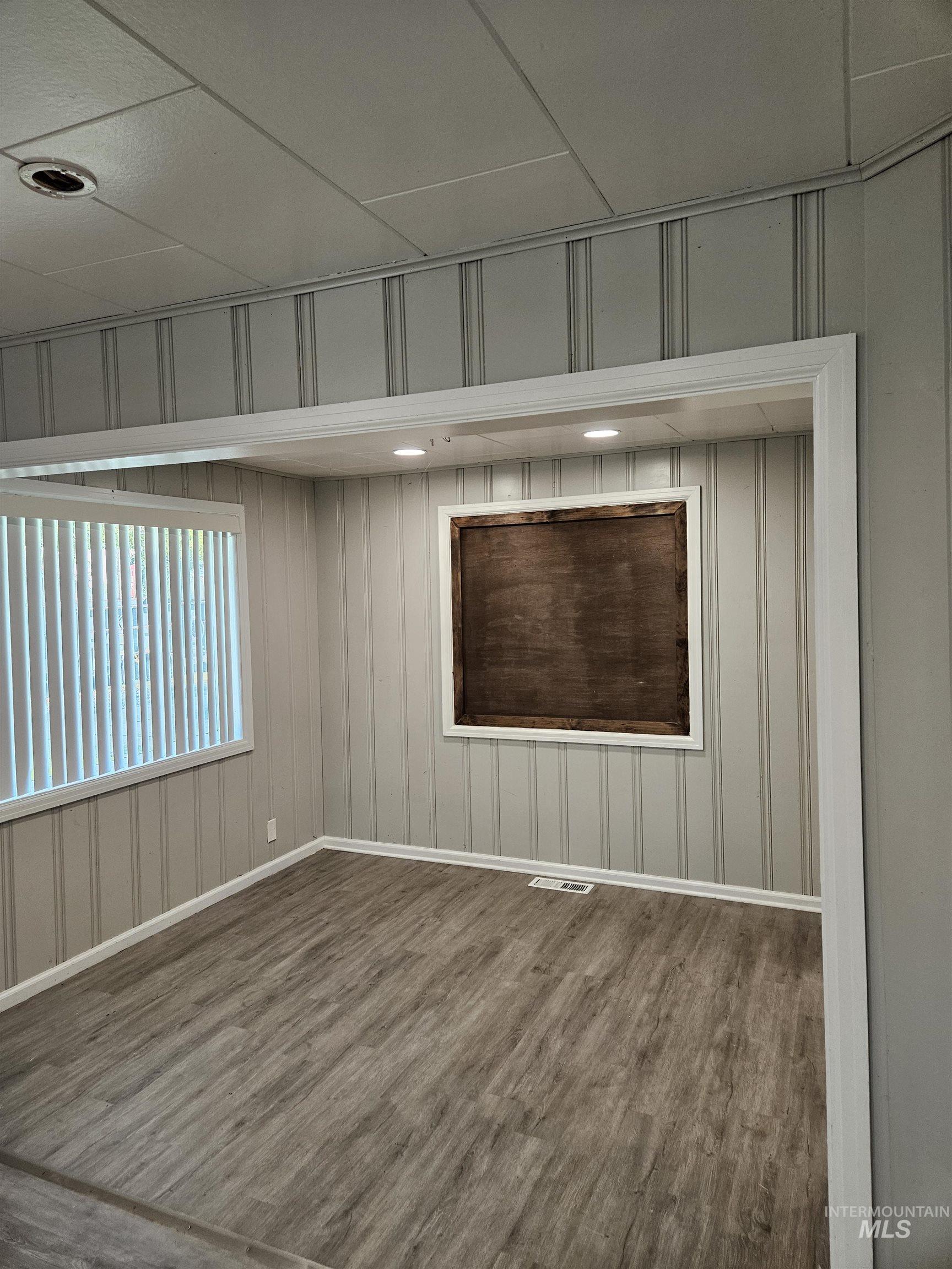 Empty room with dark wood-style flooring and recessed lighting