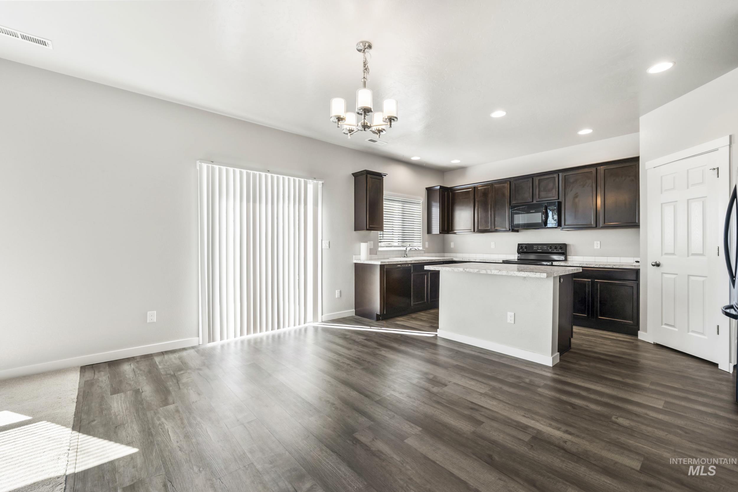 Kitchen with dark brown cabinets, recessed lighting, black appliances, a chandelier, and decorative light fixtures