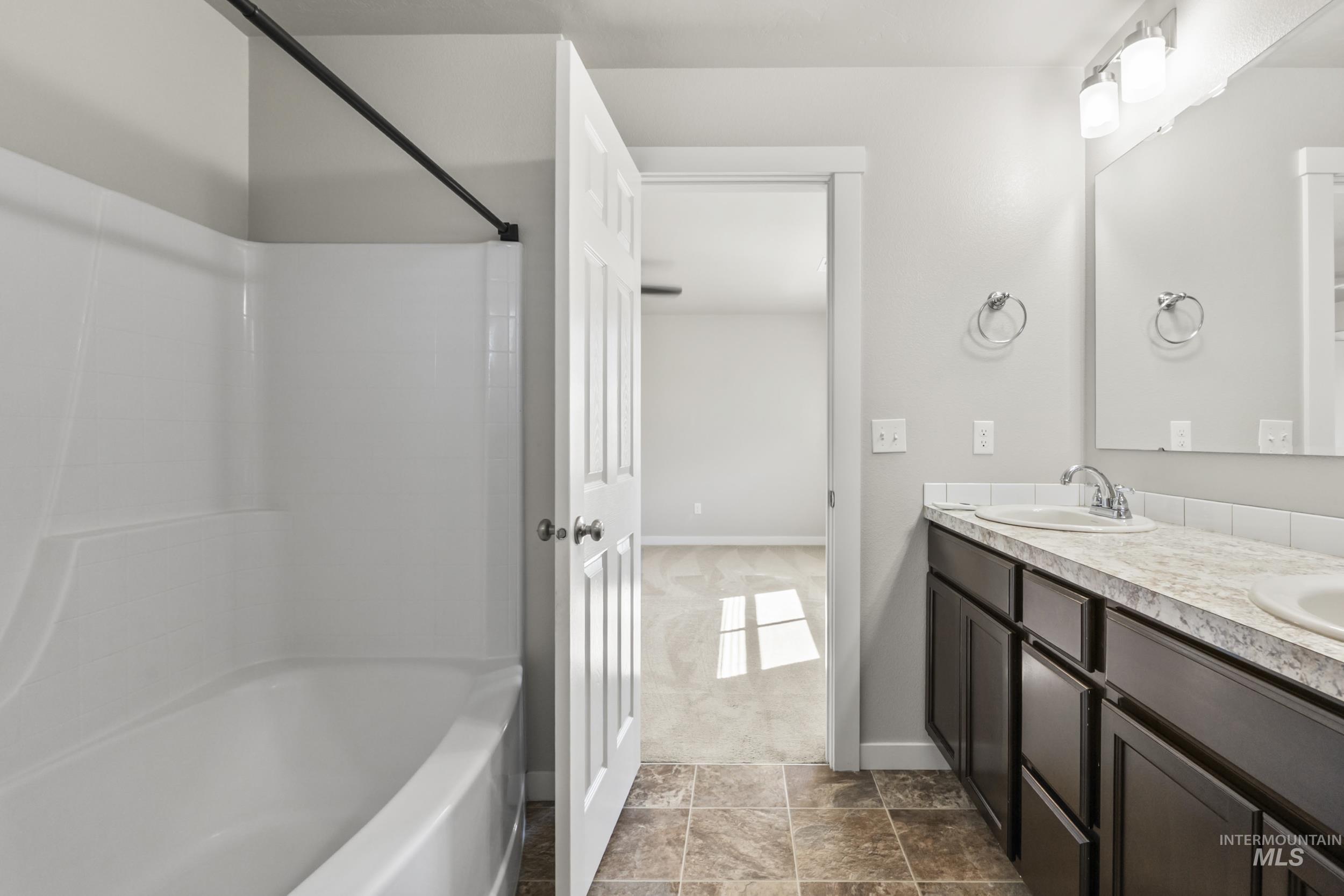 Full bathroom with double vanity and shower / bathtub combination