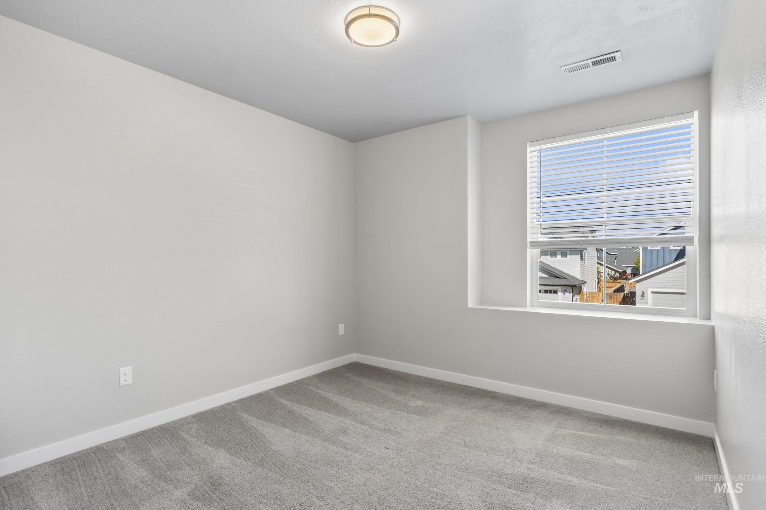 Spare room with light carpet and baseboards