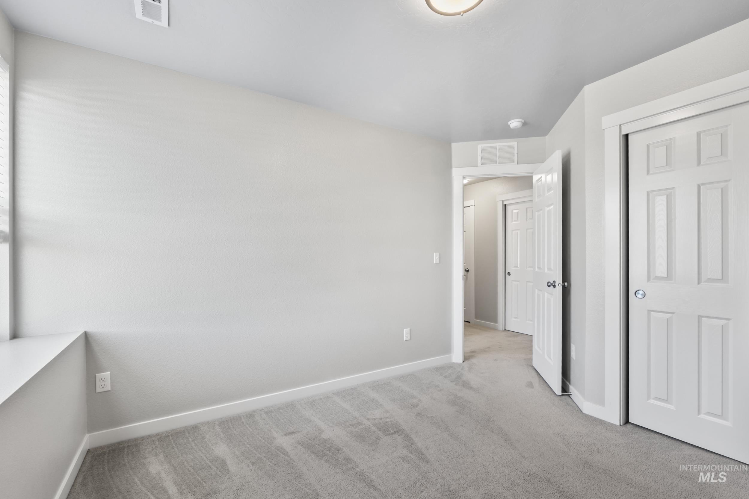 Unfurnished bedroom with light colored carpet and a closet