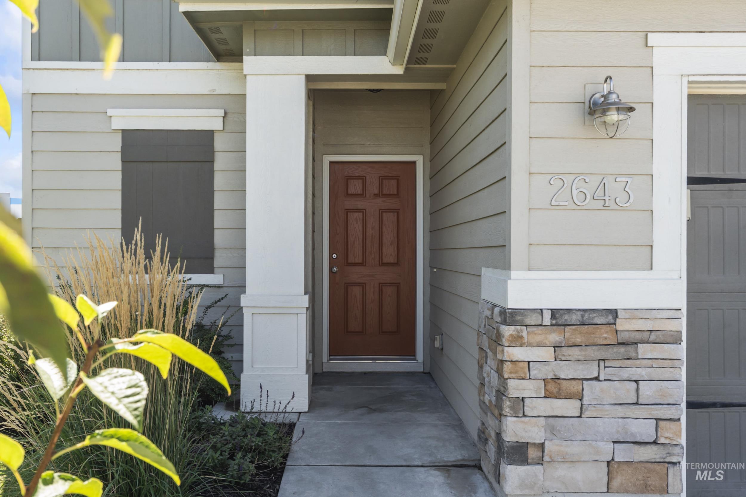 Doorway to property featuring board and batten siding and stone siding