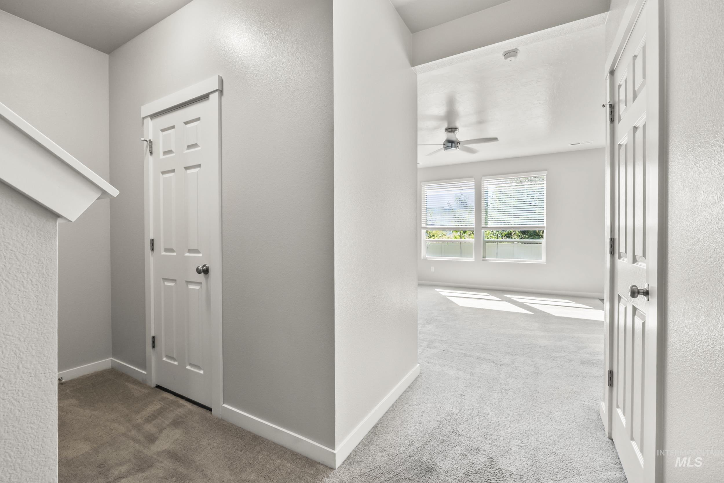 Hall featuring carpet and a textured wall