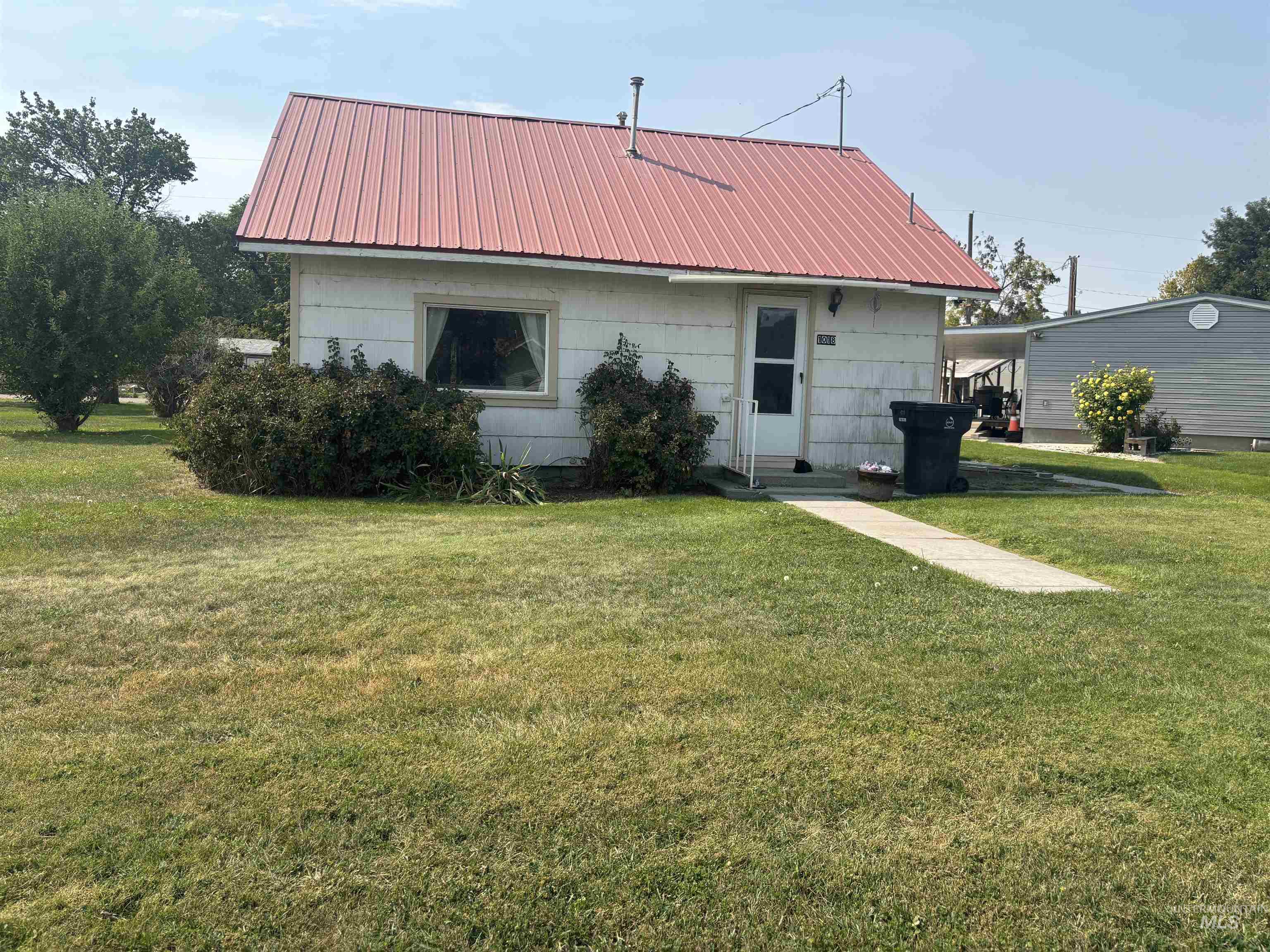 Back of house featuring a yard and a metal roof