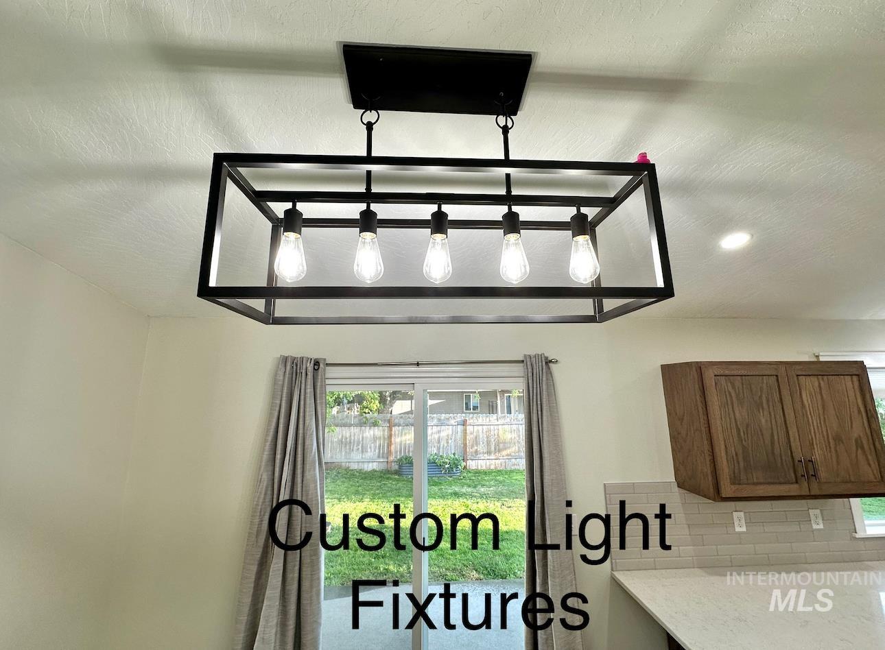 Kitchen view of tasteful backsplash, light stone counters, and recessed lighting