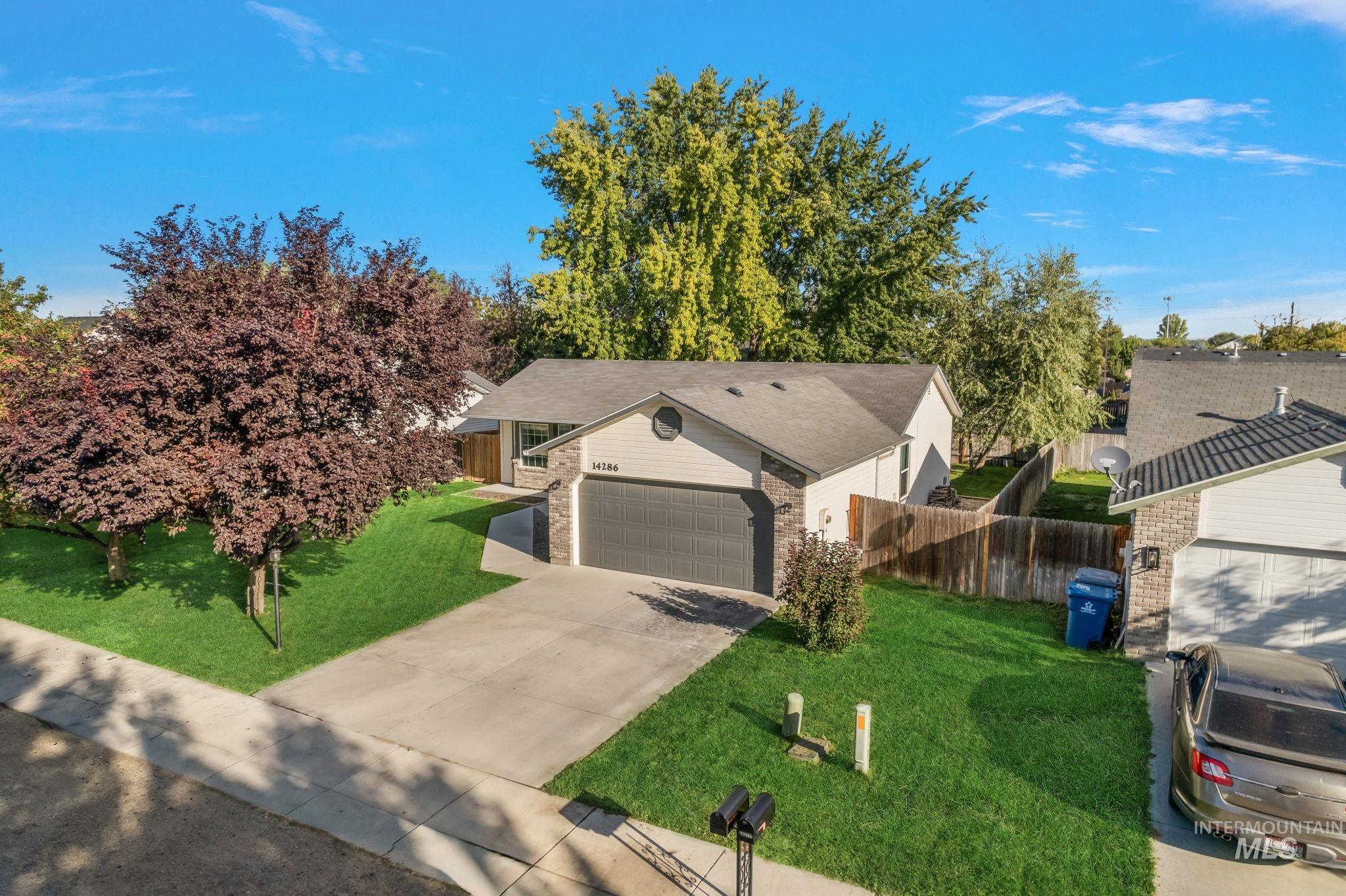 Single story home featuring driveway and brick siding
