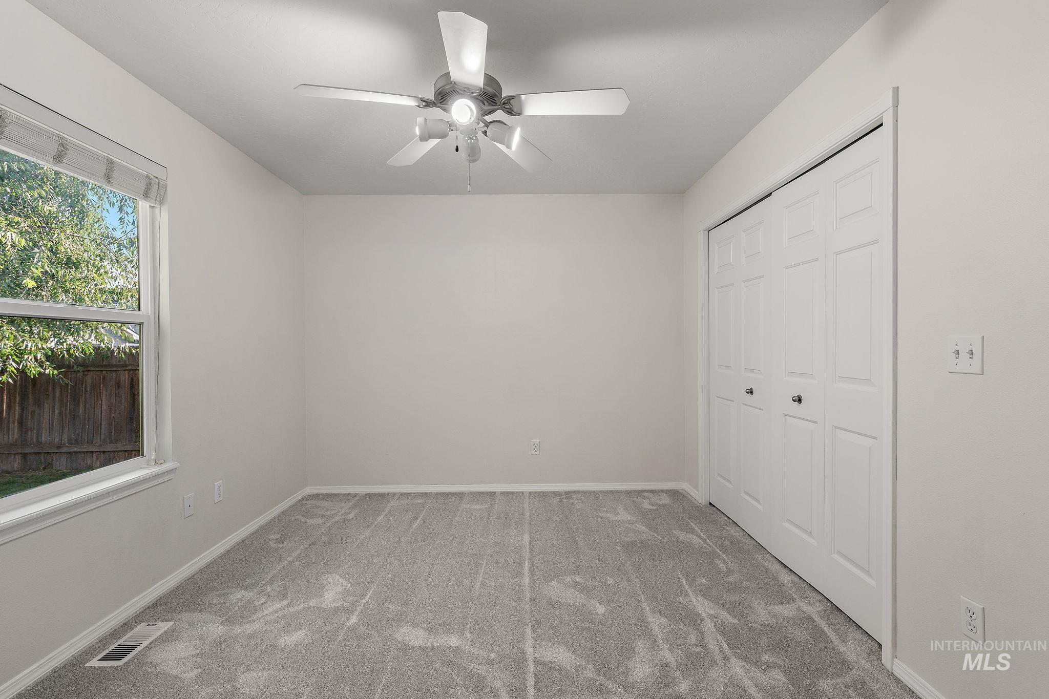 Primary bedroom featuring carpet flooring, ceiling fan, and a closet