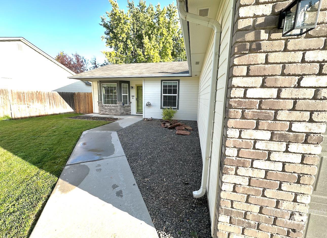 View of exterior entry featuring brick siding and a shingled roof