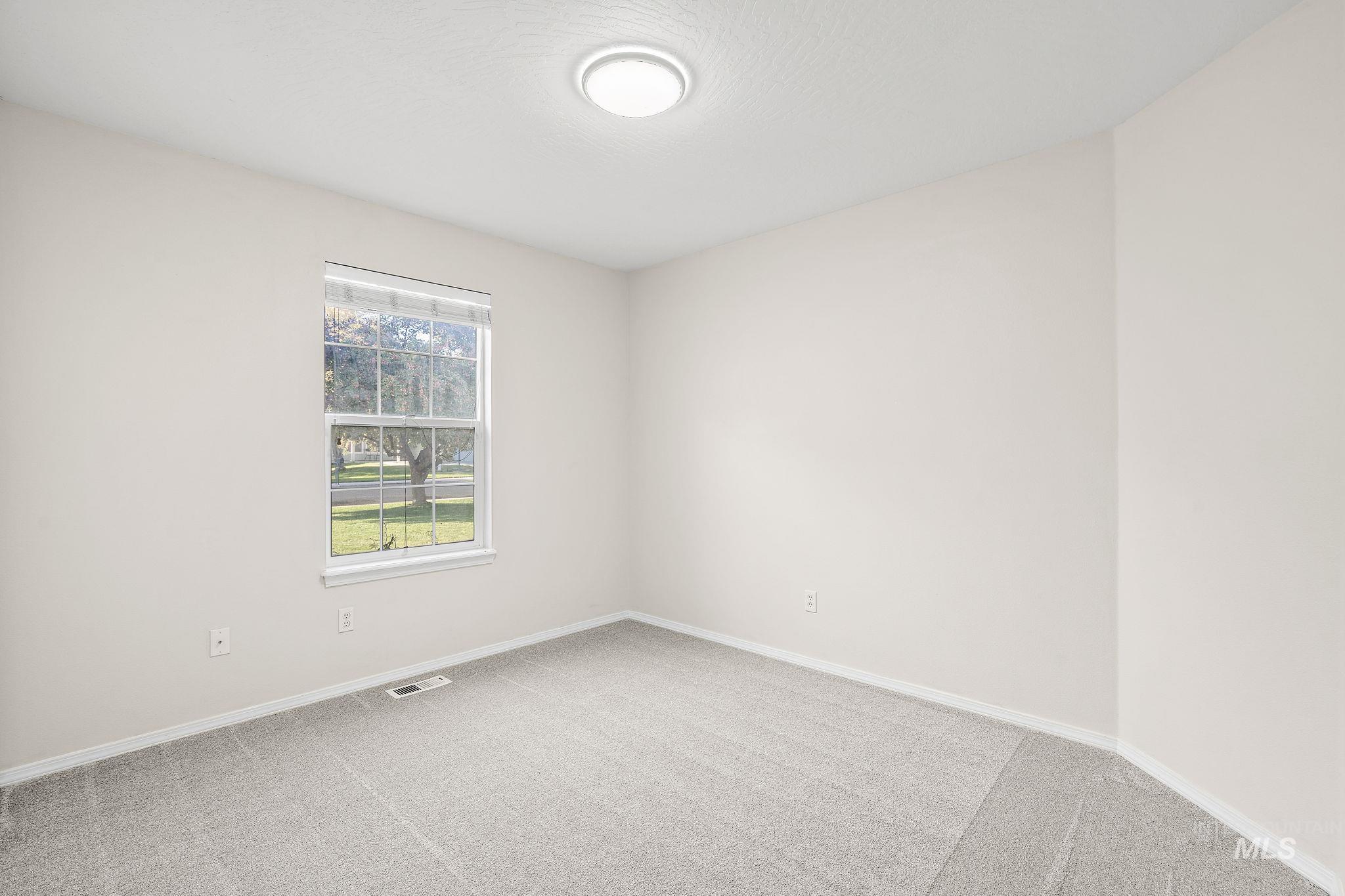 Bedroom featuring light carpet and a textured ceiling