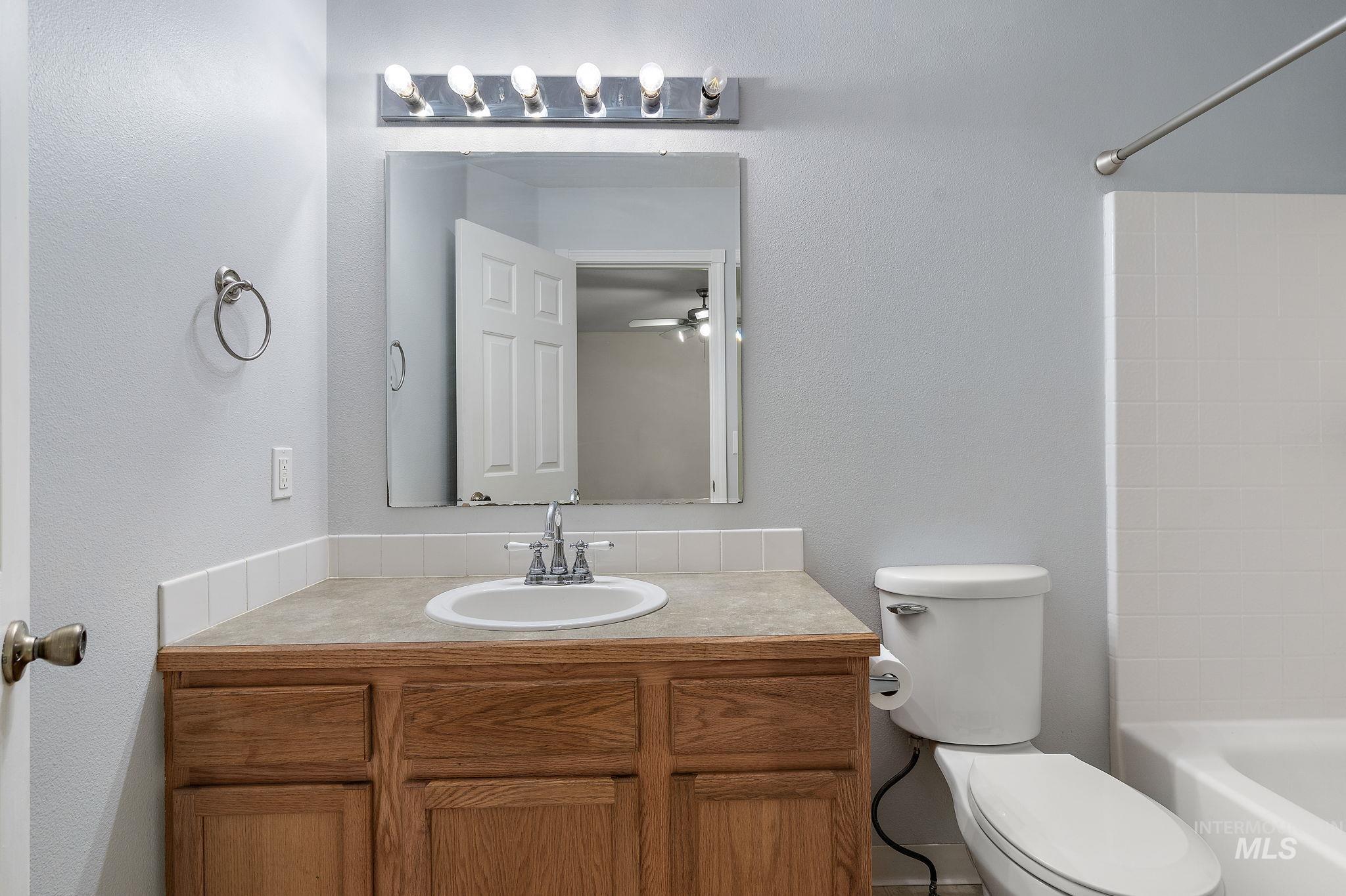Full bath featuring vanity, shower / tub combination, and a ceiling fan