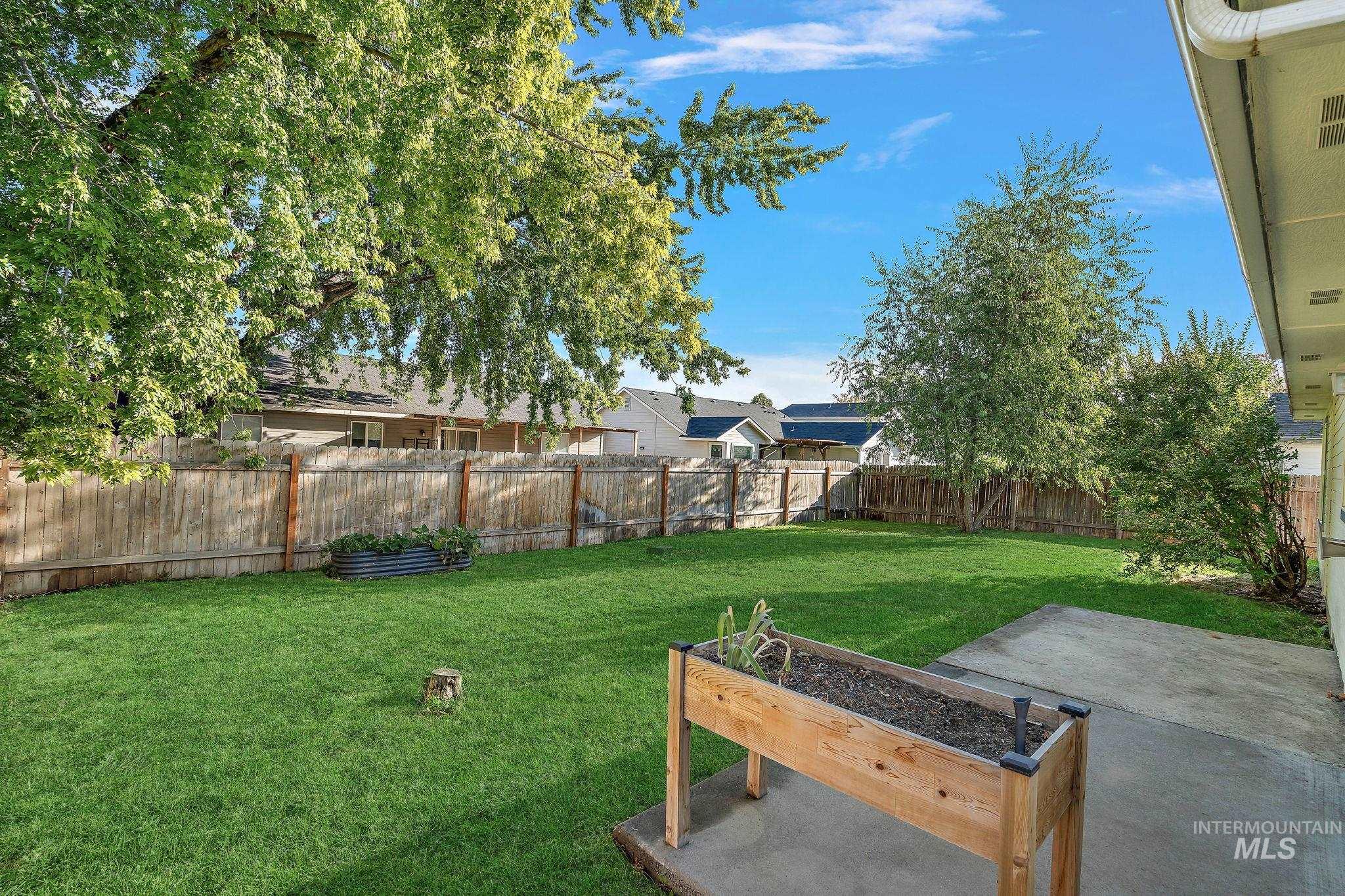 Fenced backyard with a garden and a patio