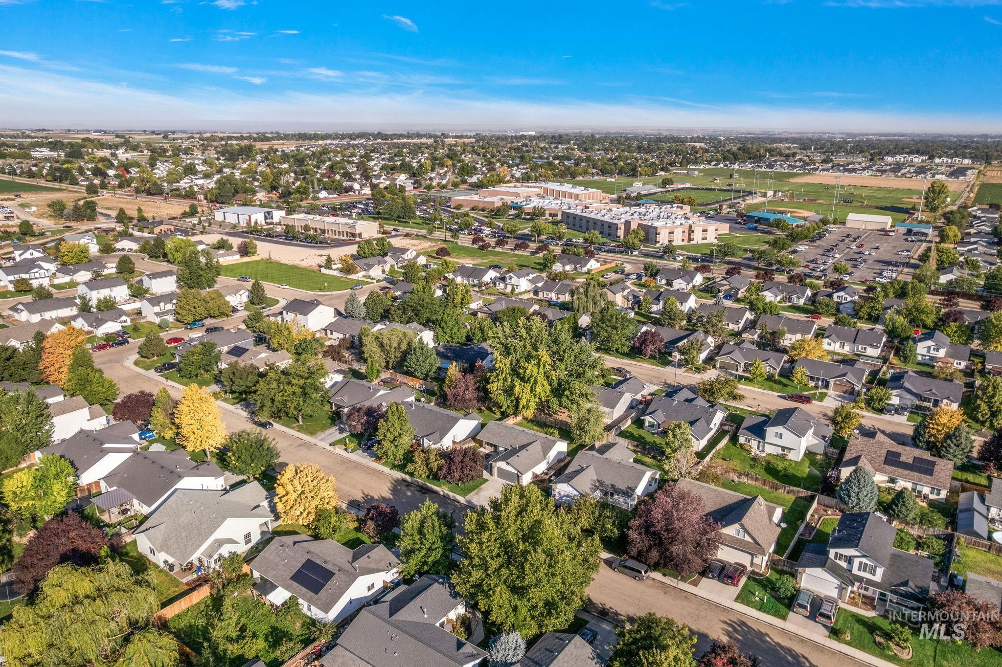 Aerial view of property and surrounding area featuring nearby suburban area