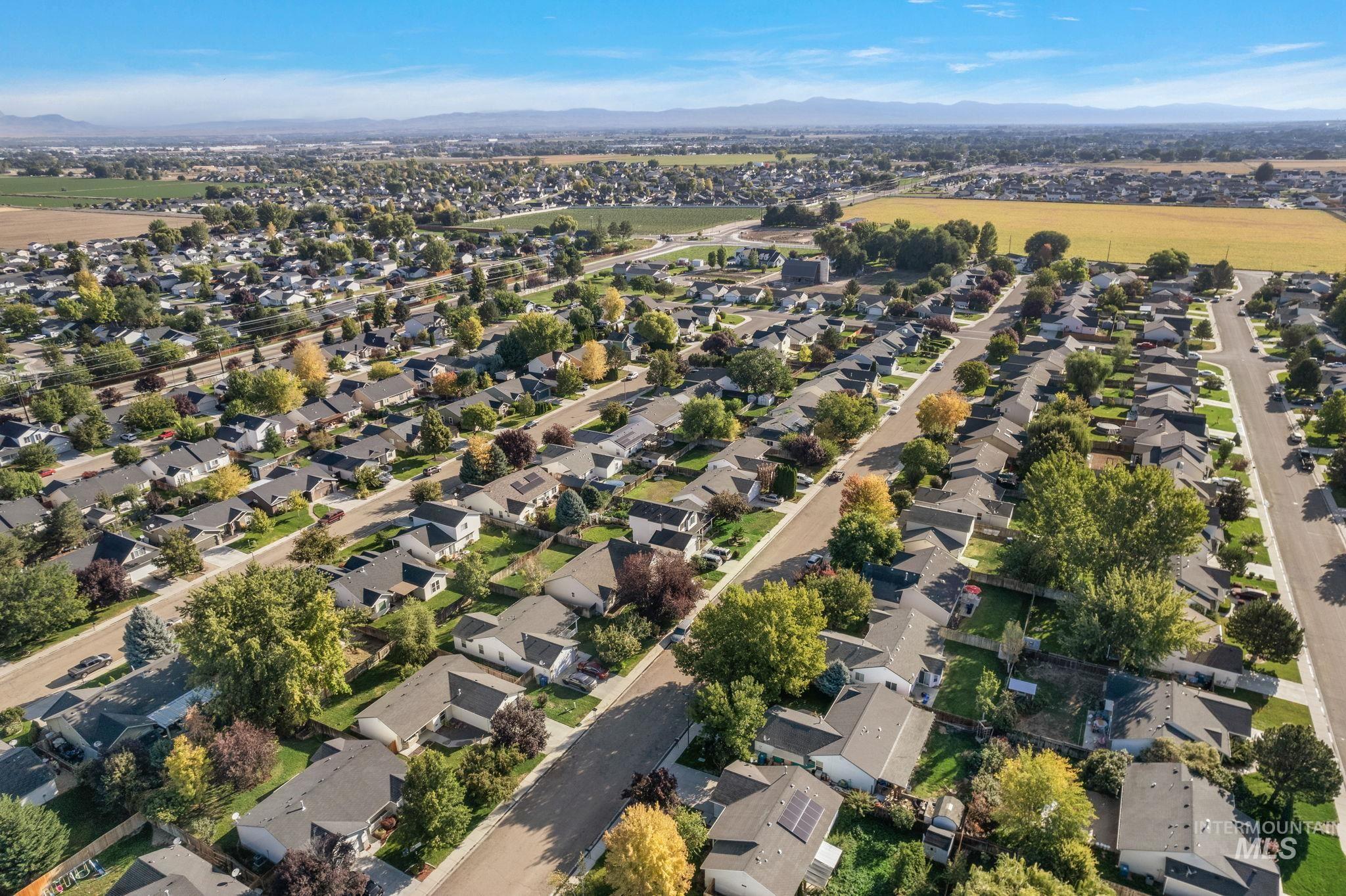 Aerial view of property's location with nearby suburban area and a mountain backdrop