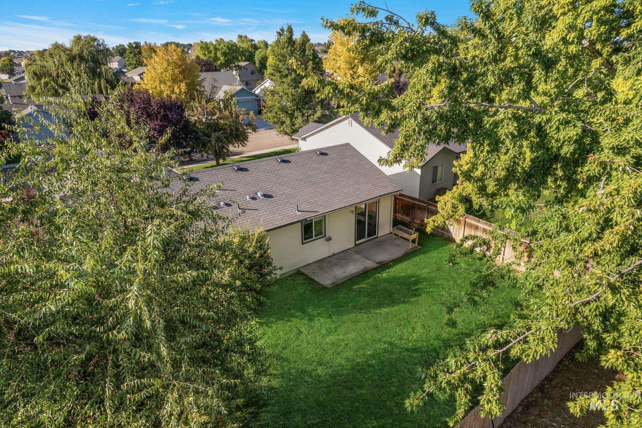 Aerial view of property and surrounding area with a tree filled landscape