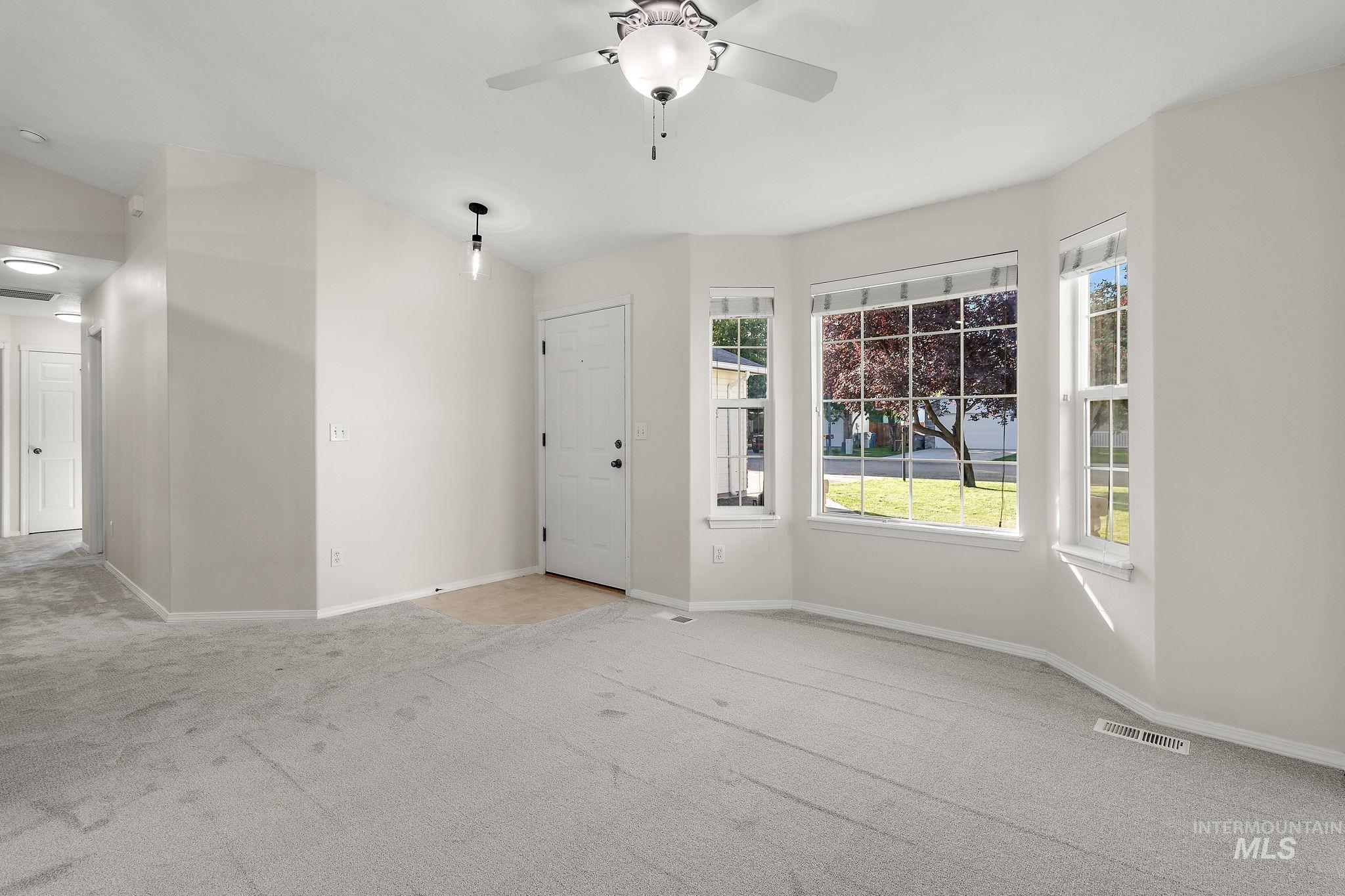 Foyer featuring carpet and a ceiling fan