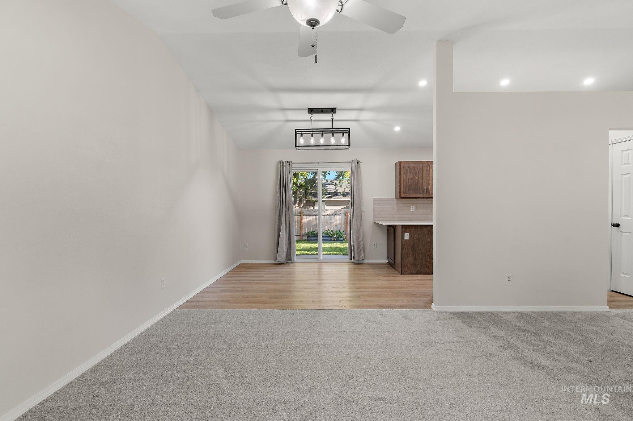 Unfurnished living room with light colored carpet, vaulted ceiling, recessed lighting, and a ceiling fan