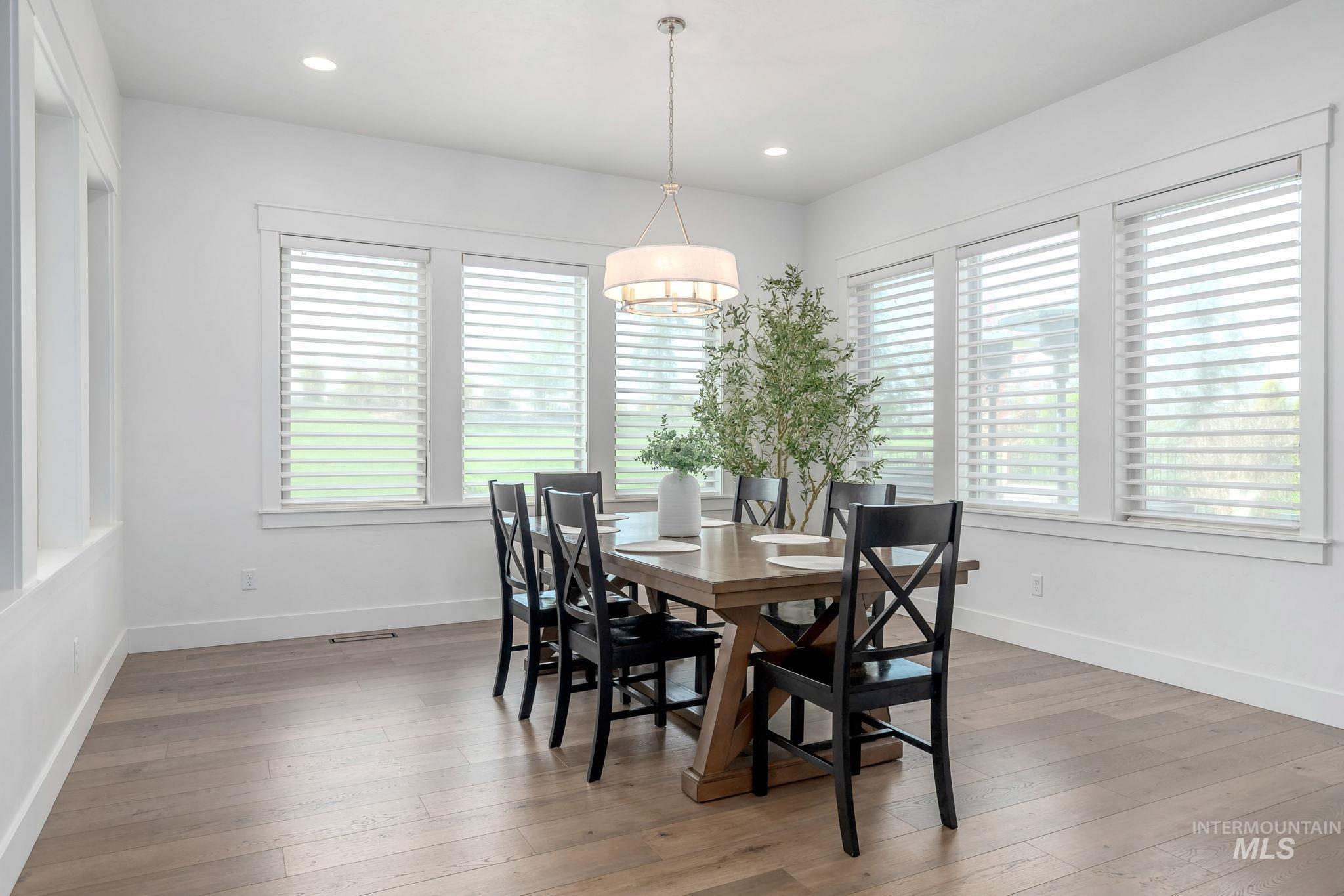 Dining area with light wood finished floors and recessed lighting