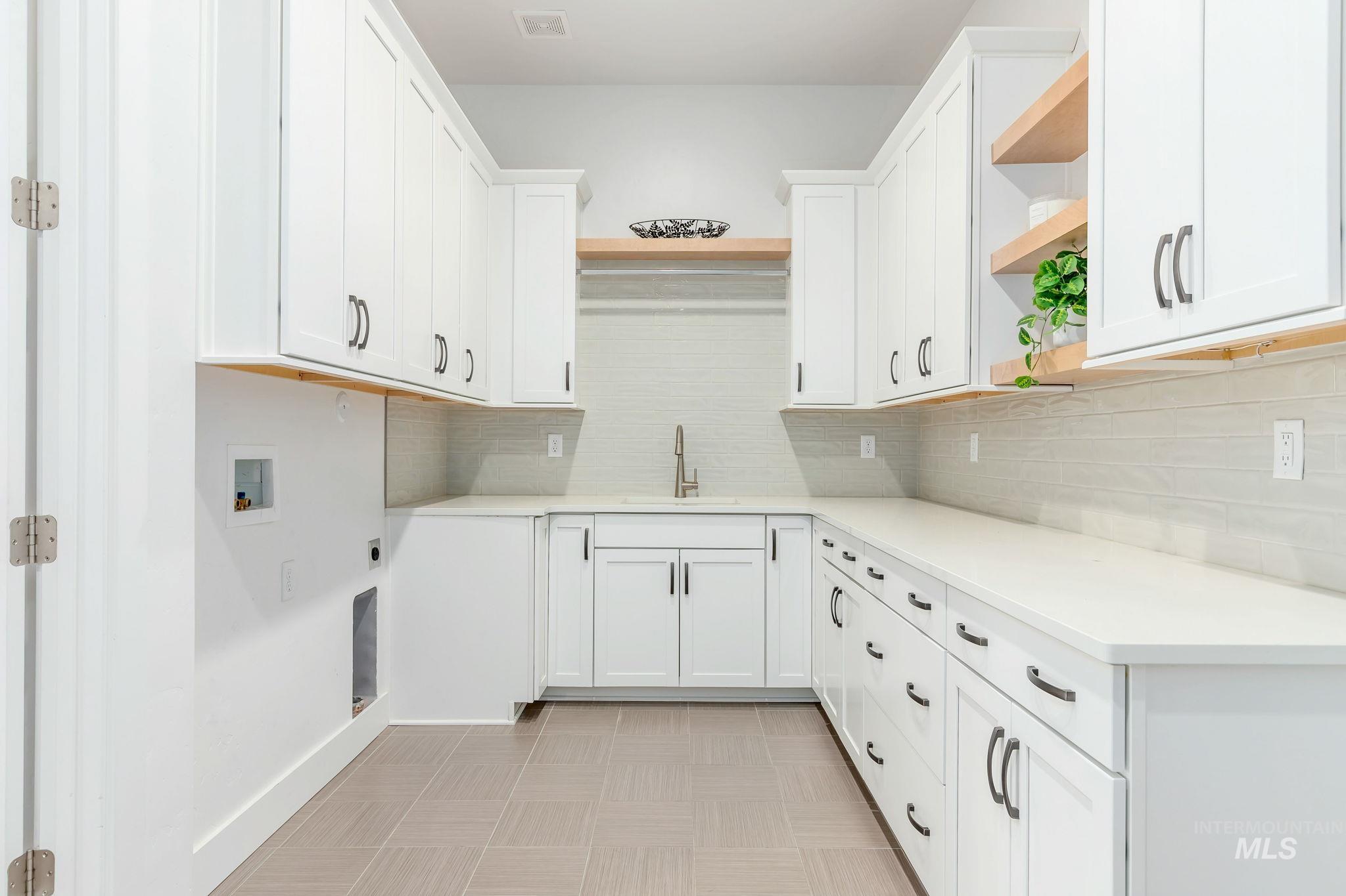 Laundry room with cabinet space, hookup for a washing machine, electric dryer hookup, and light flooring