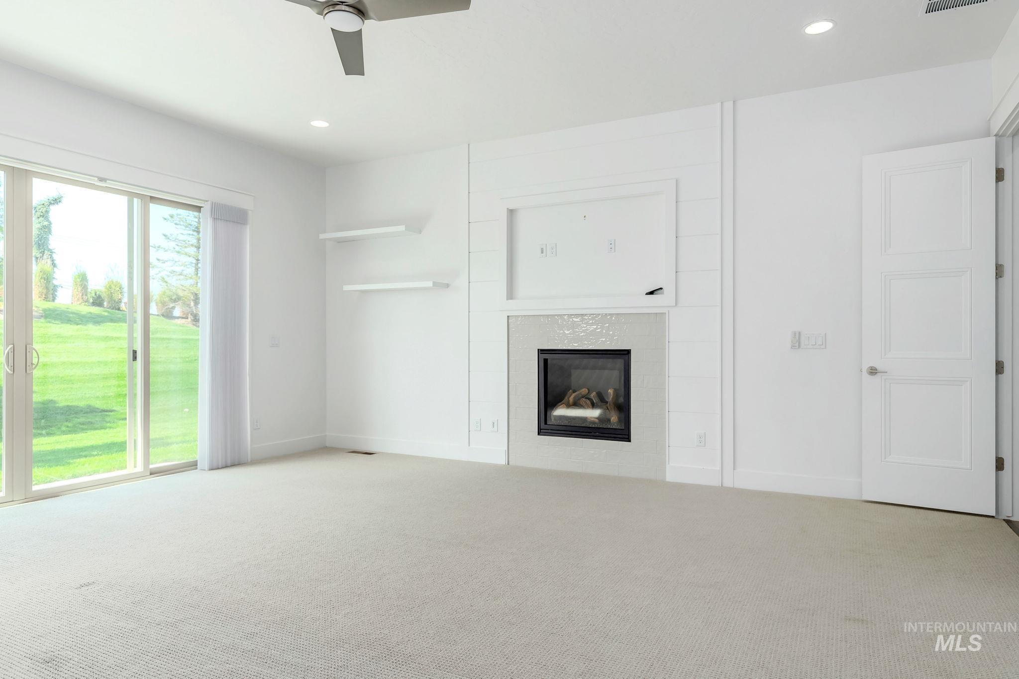 Unfurnished living room with a fireplace, carpet flooring, a ceiling fan, and recessed lighting