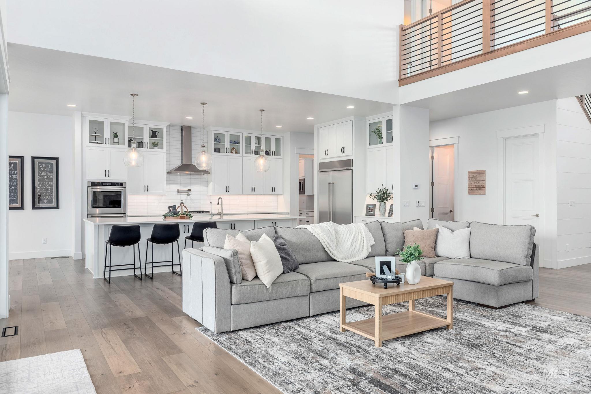 Living room featuring light wood-style floors, recessed lighting, and a high ceiling