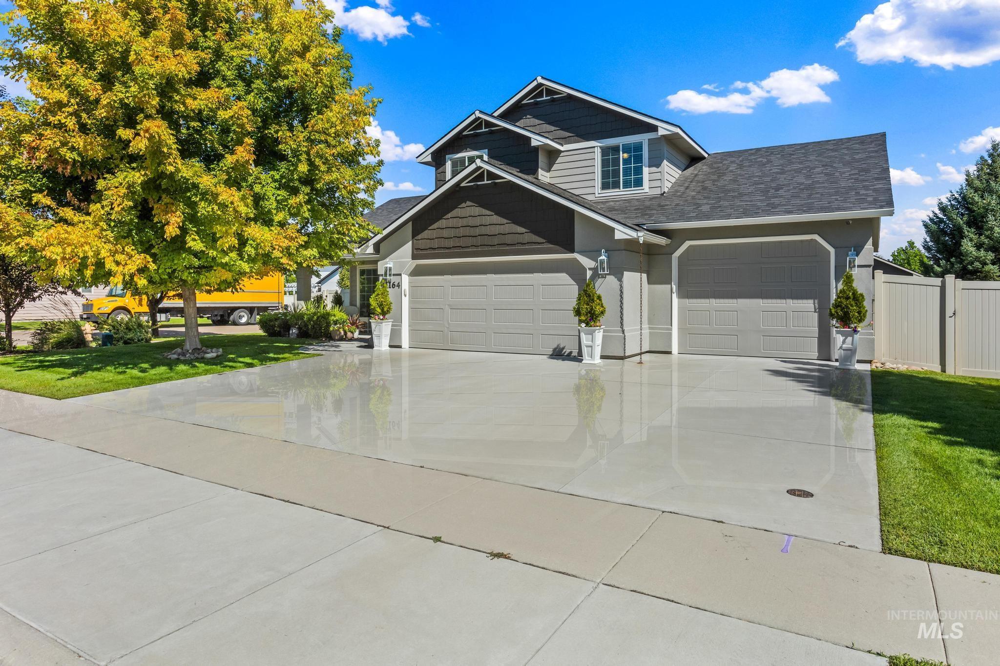Craftsman-style home featuring roof with shingles, concrete driveway, a front yard, and a garage
