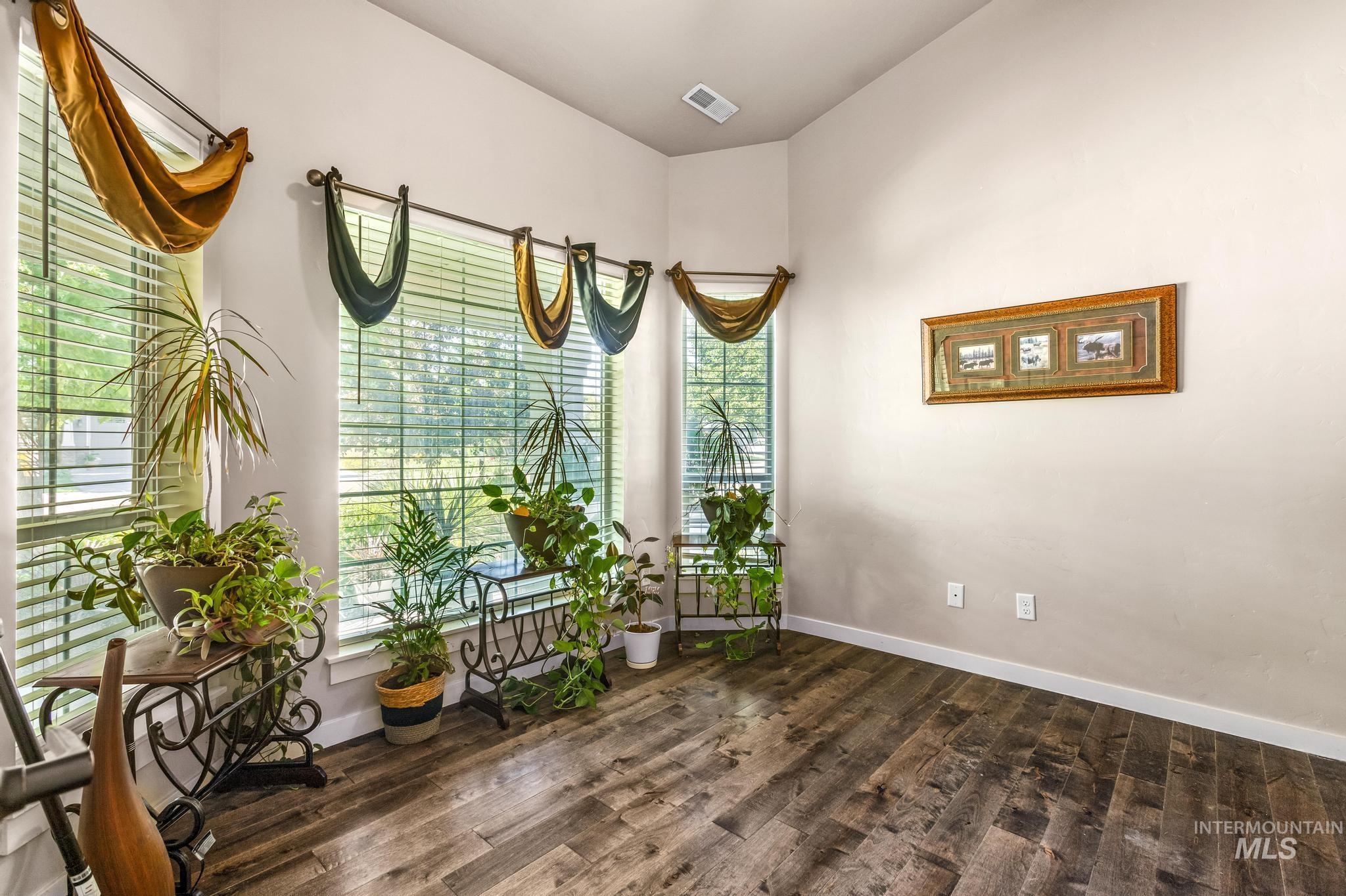 Spare room with plenty of natural light and dark wood-type flooring