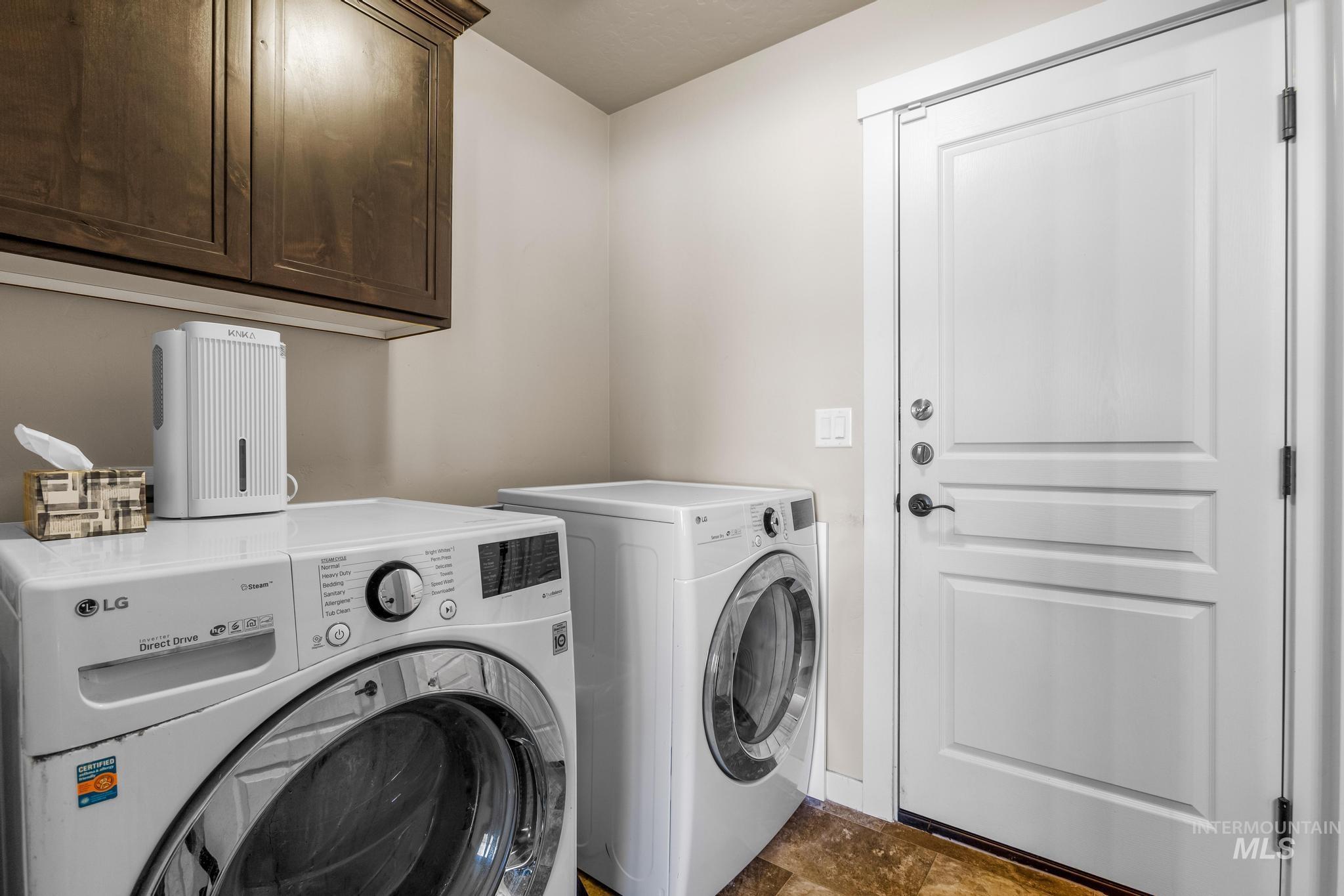 Washroom featuring separate washer and dryer and cabinet space