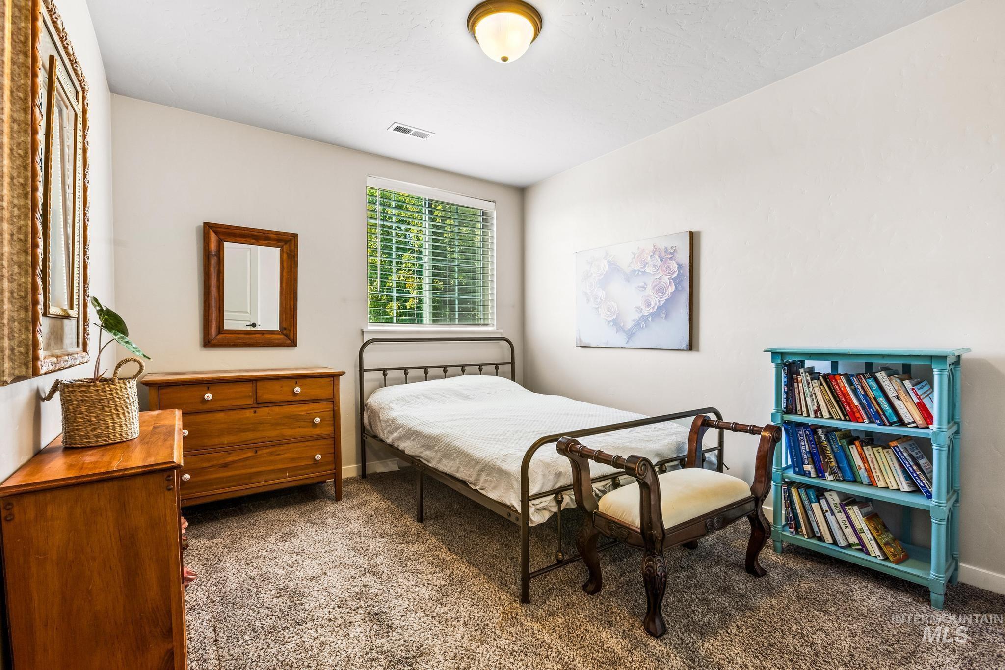Bedroom with dark colored carpet and baseboards