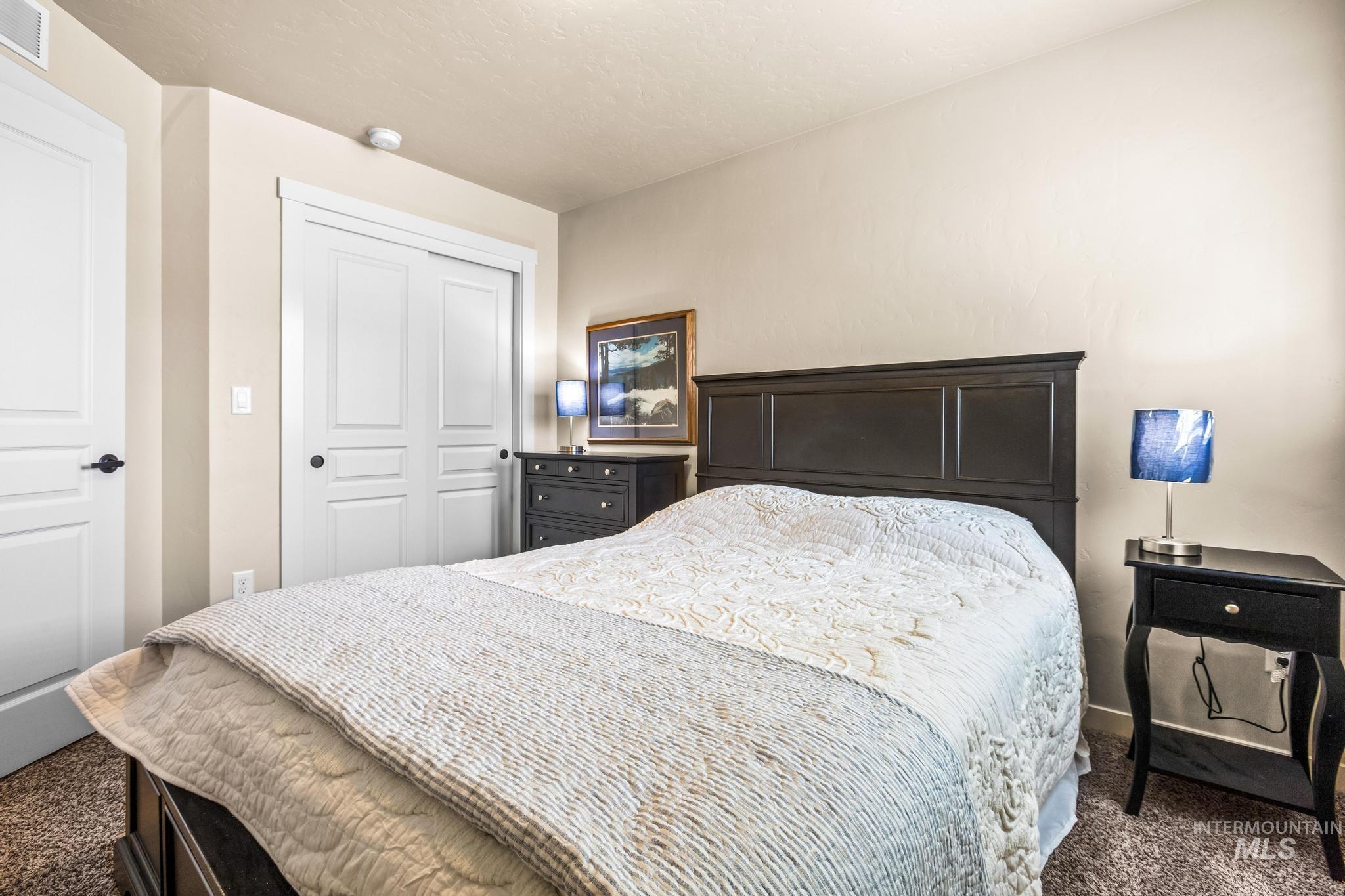 Bedroom featuring dark colored carpet and a closet