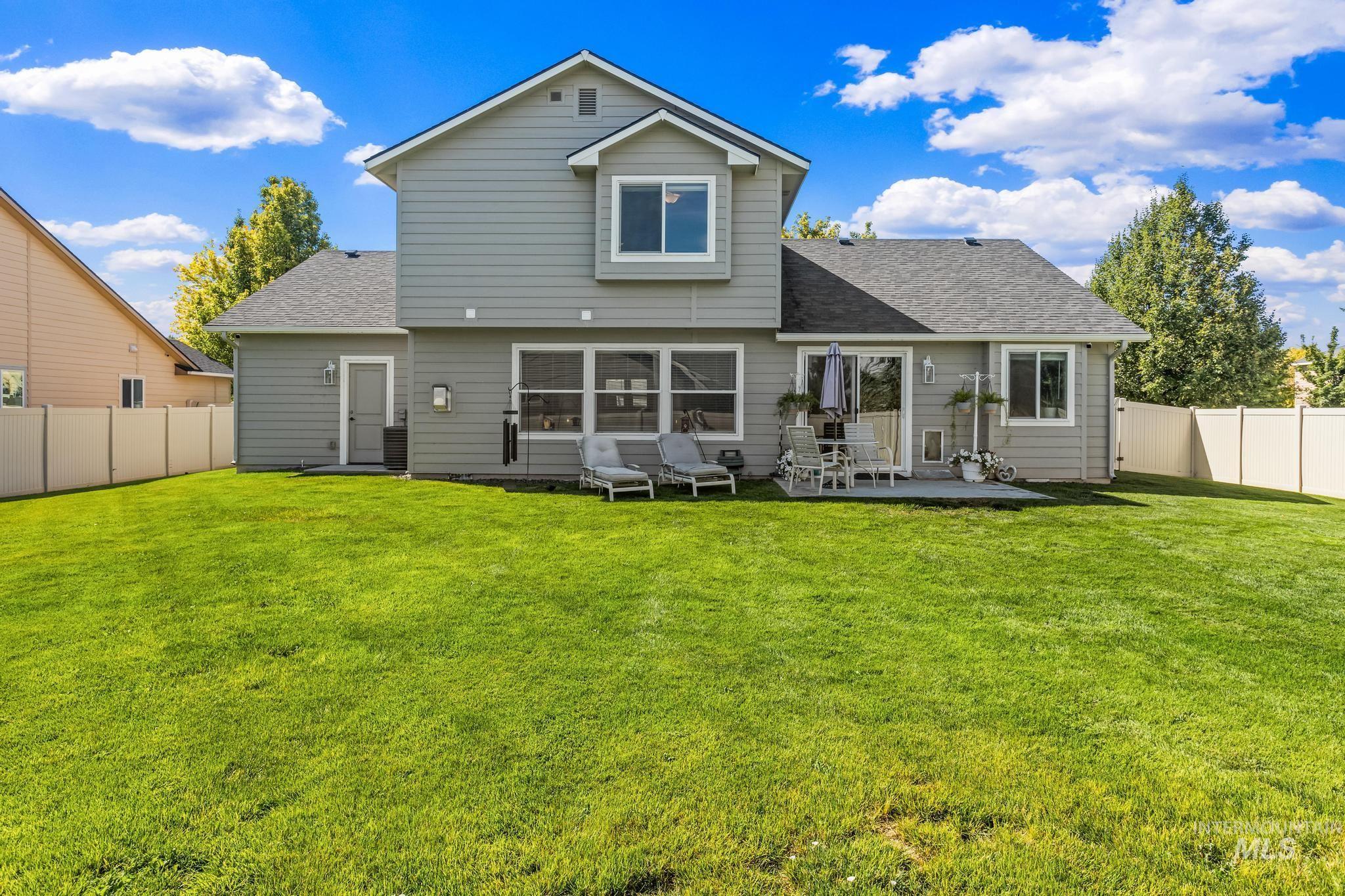 Back of property featuring roof with shingles, a fenced backyard, and a patio area