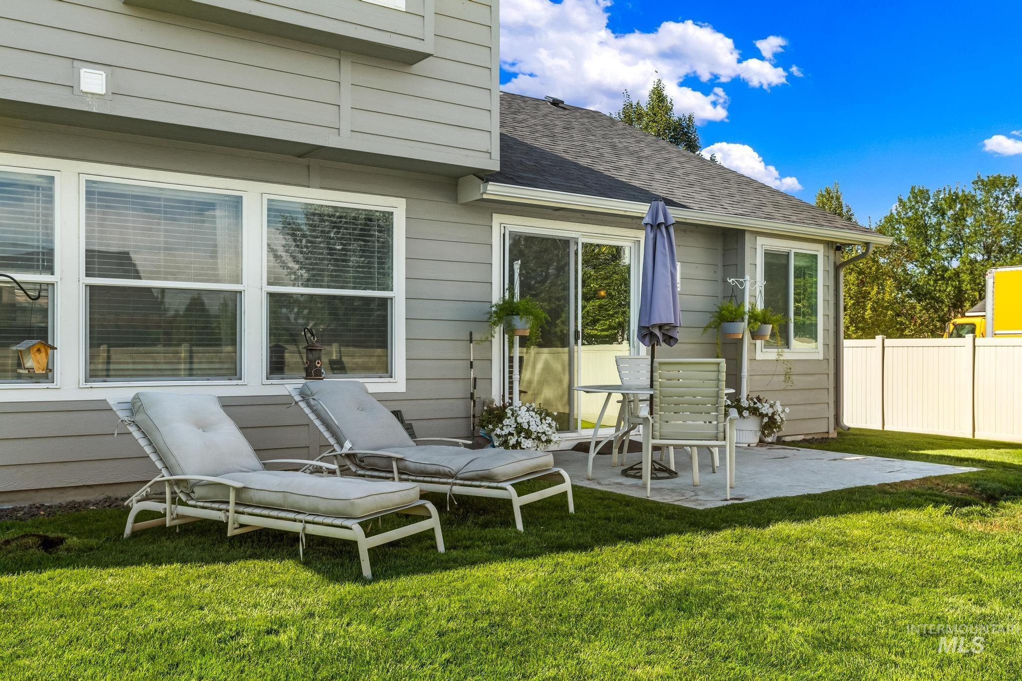 Back of property with a patio area and a shingled roof