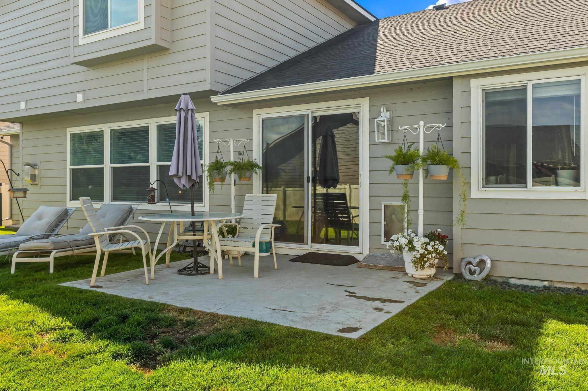 Rear view of property with a patio, a lawn, and roof with shingles