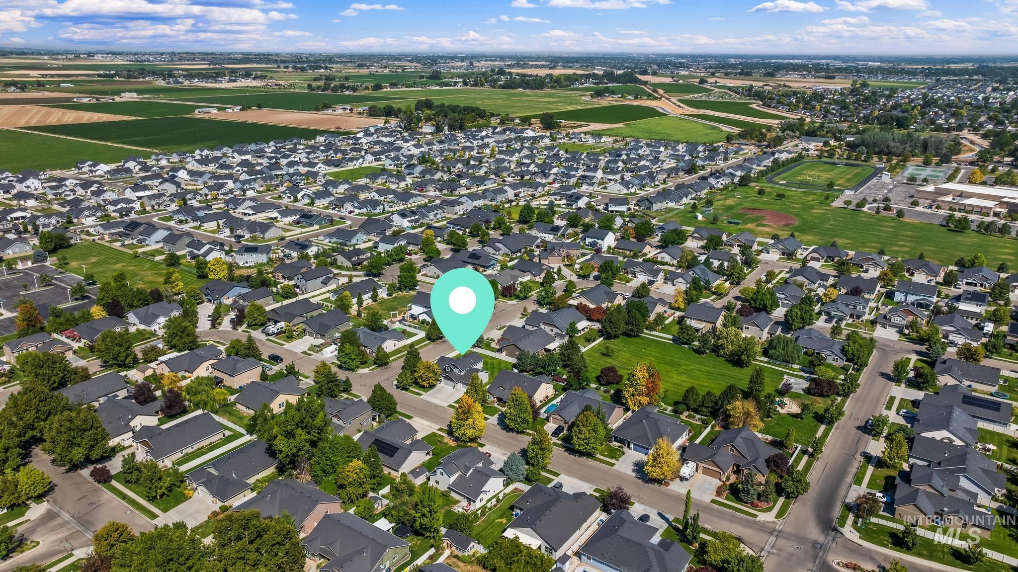 Aerial view of property and surrounding area with nearby suburban area