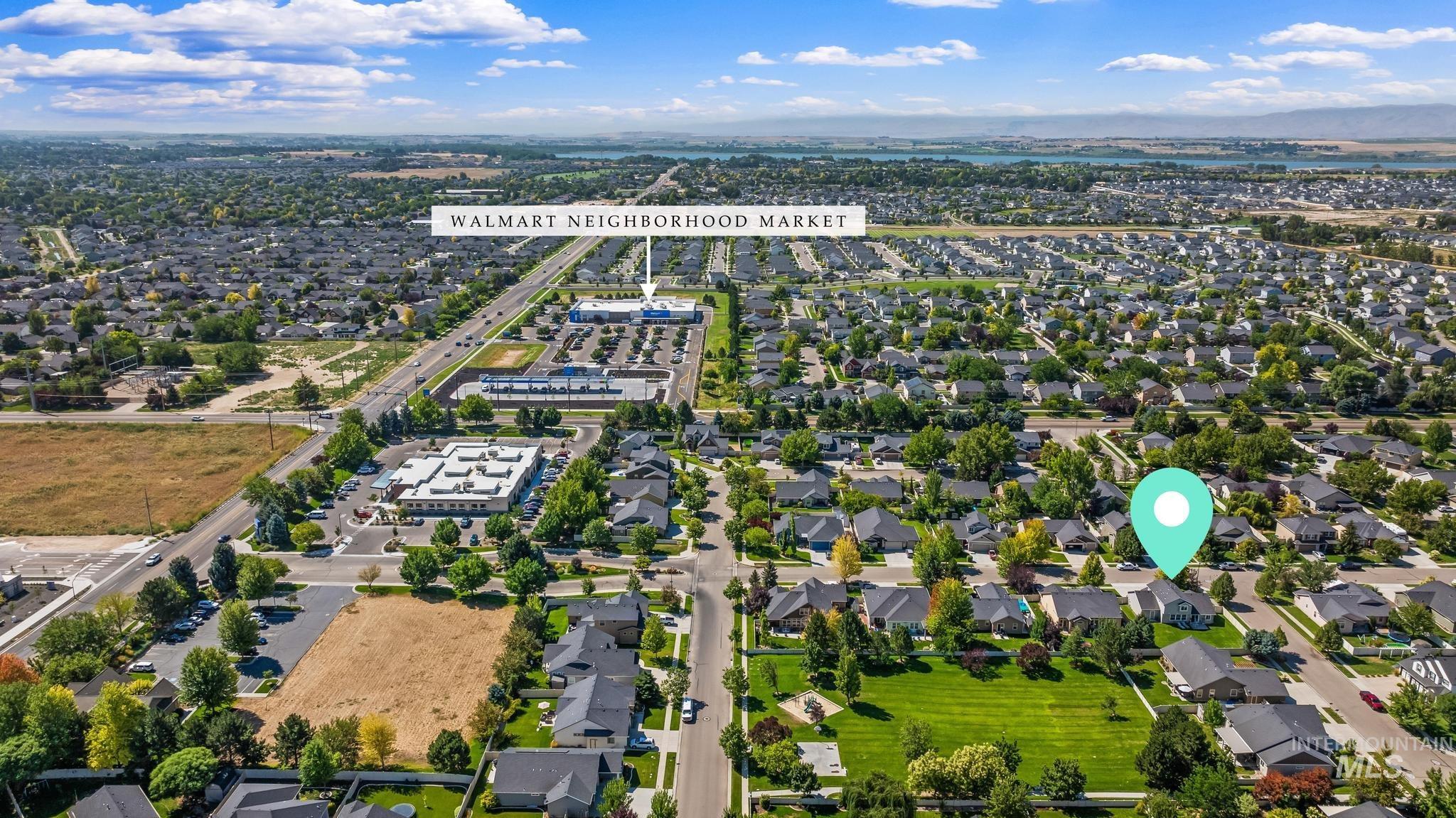 Aerial view of property and surrounding area with nearby suburban area