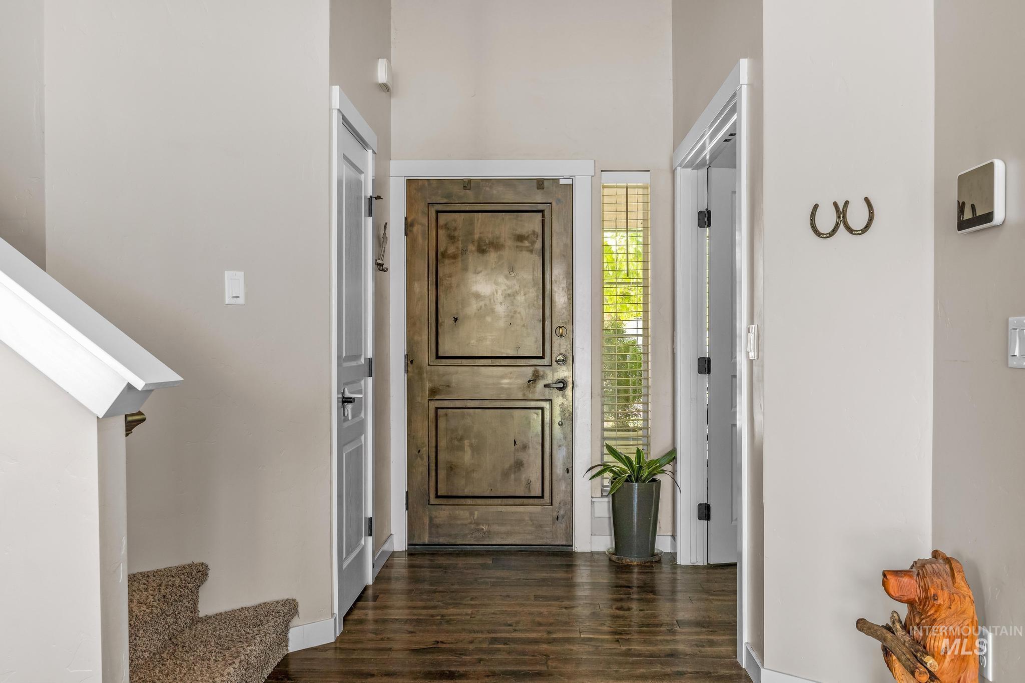 Entryway with stairs and dark wood-type flooring