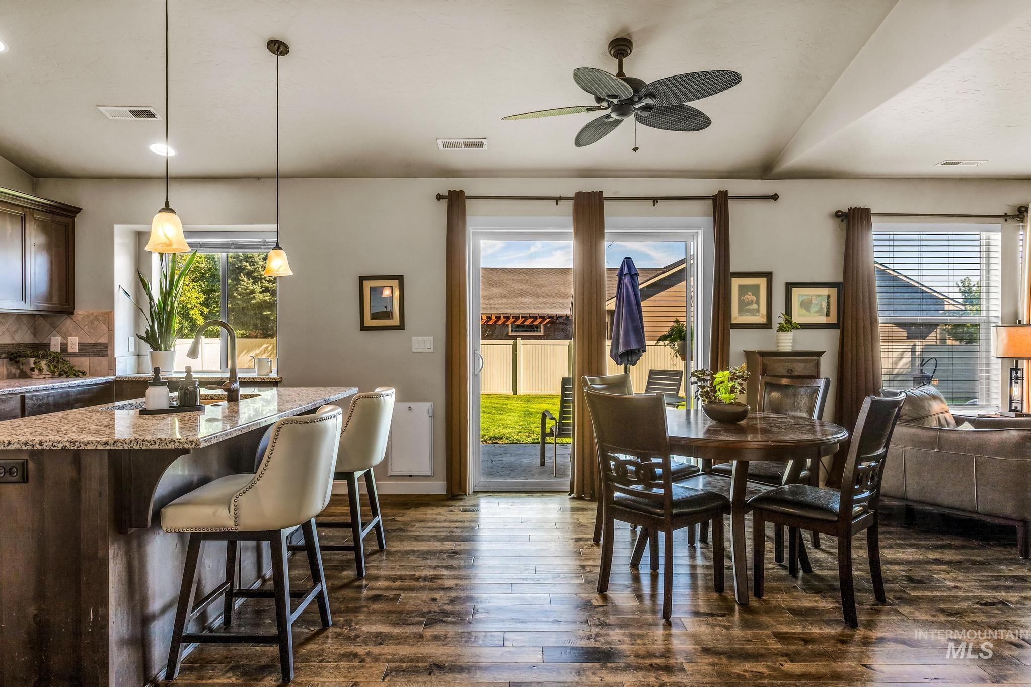 Dining area featuring dark wood-style floors, healthy amount of natural light, and a ceiling fan