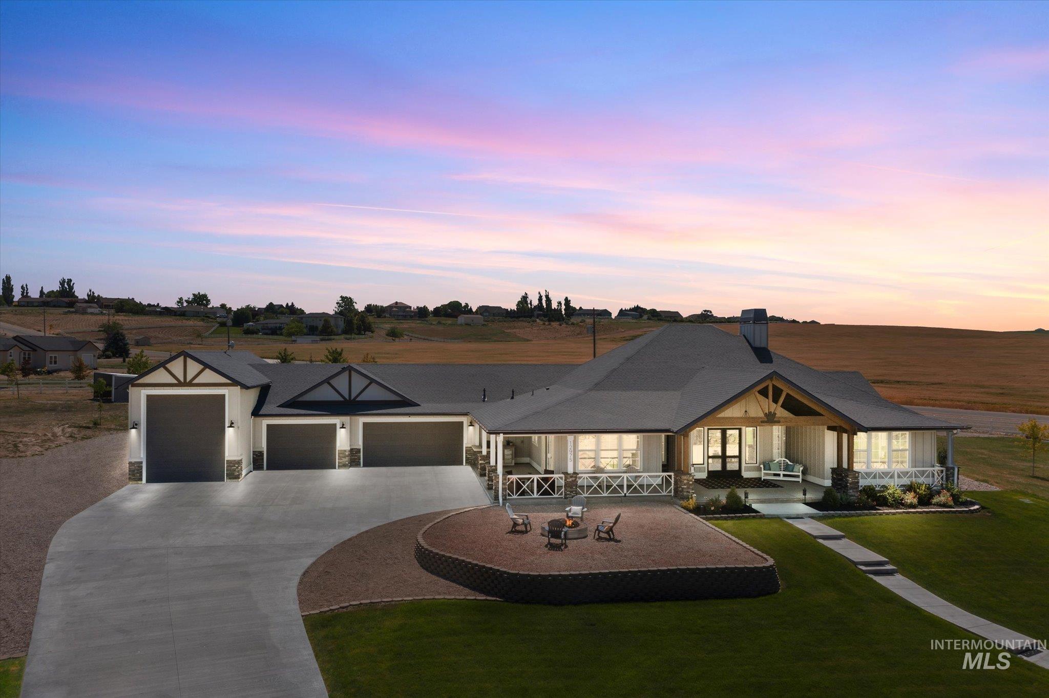 View of front of property with a garage, a front yard, curved driveway, a porch, and stone siding