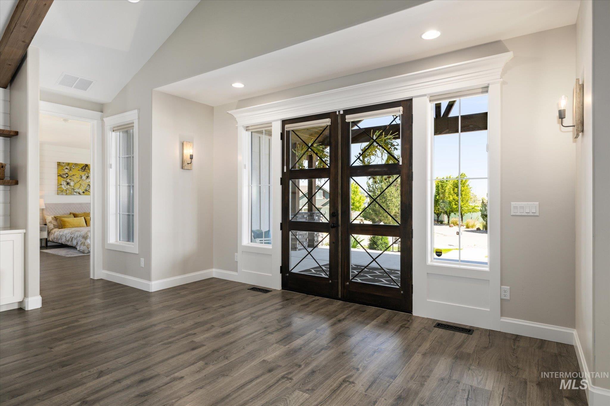 Entryway with dark wood-style floors, healthy amount of natural light, vaulted ceiling, and recessed lighting