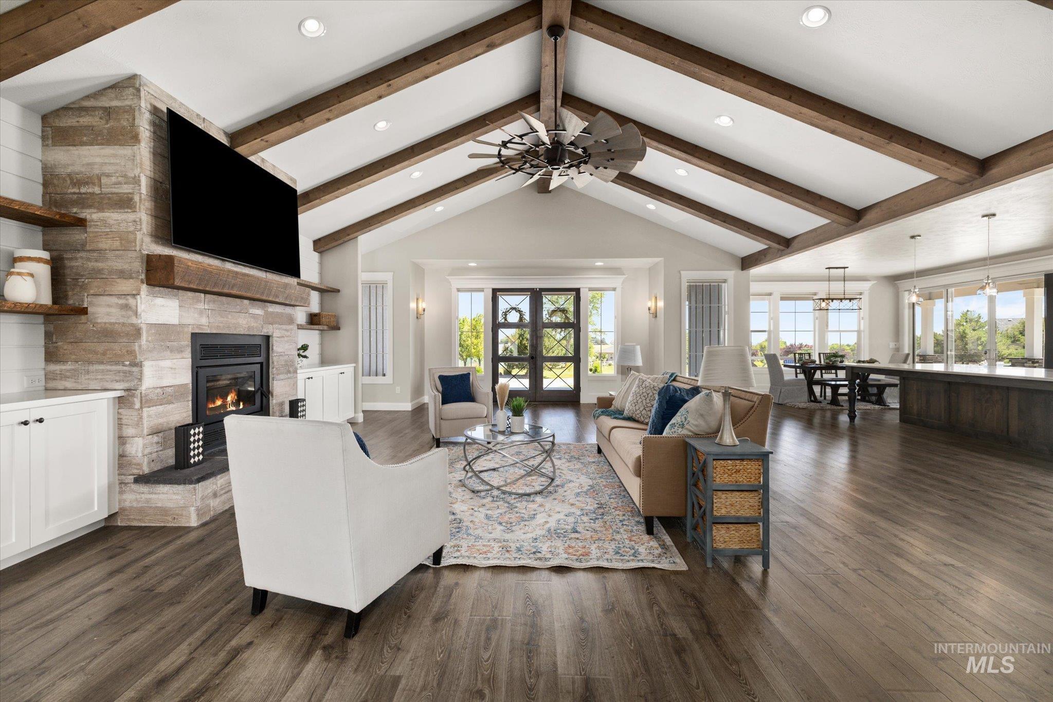 Living room with a fireplace, dark wood-style floors, recessed lighting, and a ceiling fan