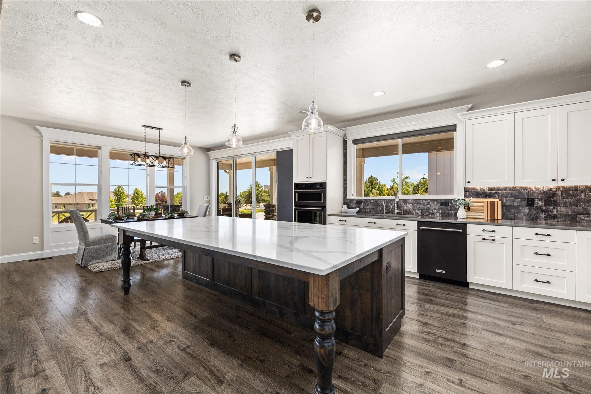 Kitchen featuring black appliances, tasteful backsplash, a center island, dark wood finished floors, and recessed lighting