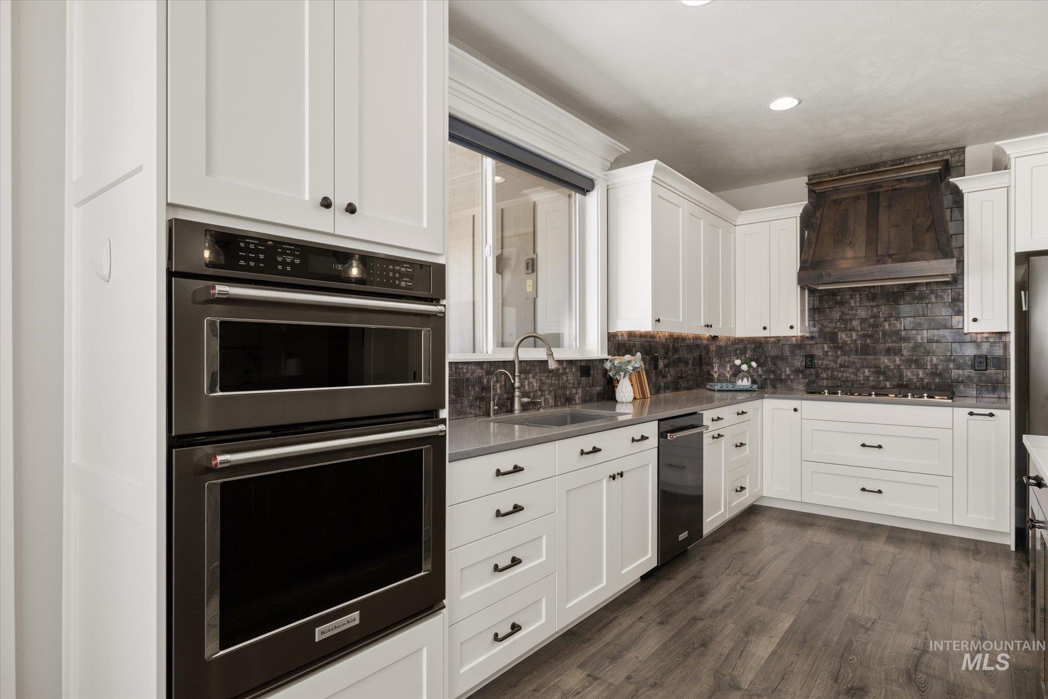 Kitchen with dishwasher, extractor fan, white cabinetry, tasteful backsplash, and recessed lighting