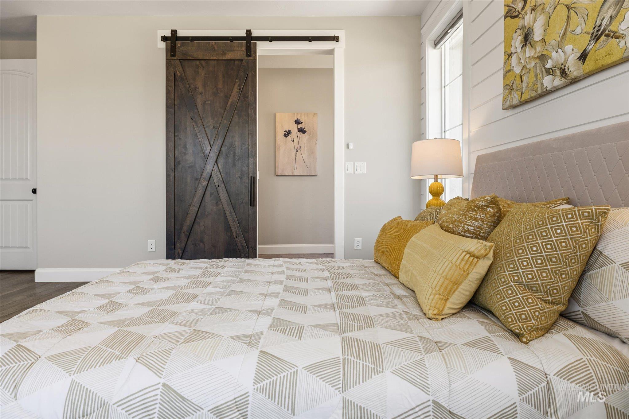 Bedroom featuring a barn door and baseboards