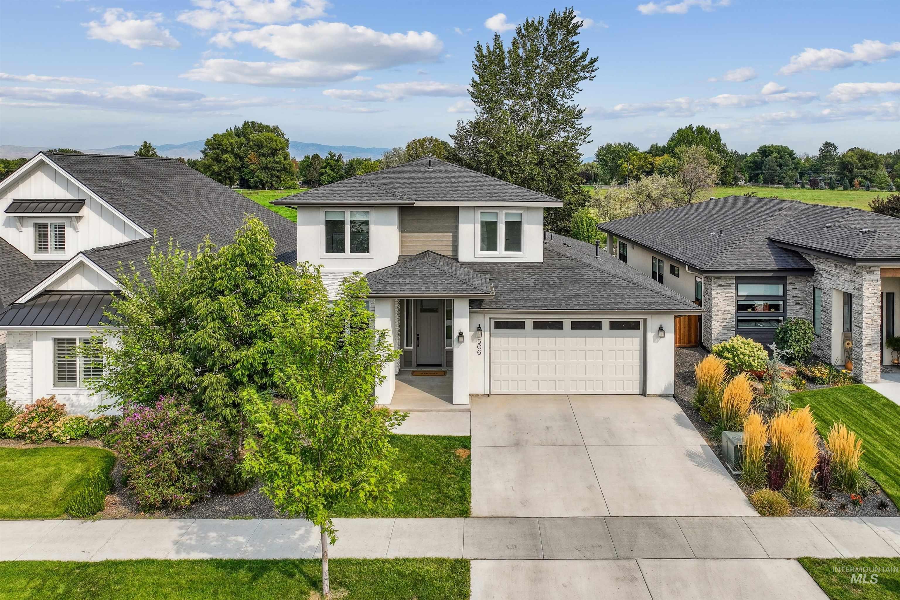 Prairie-style home featuring roof with shingles, concrete driveway, stone siding, and stucco siding