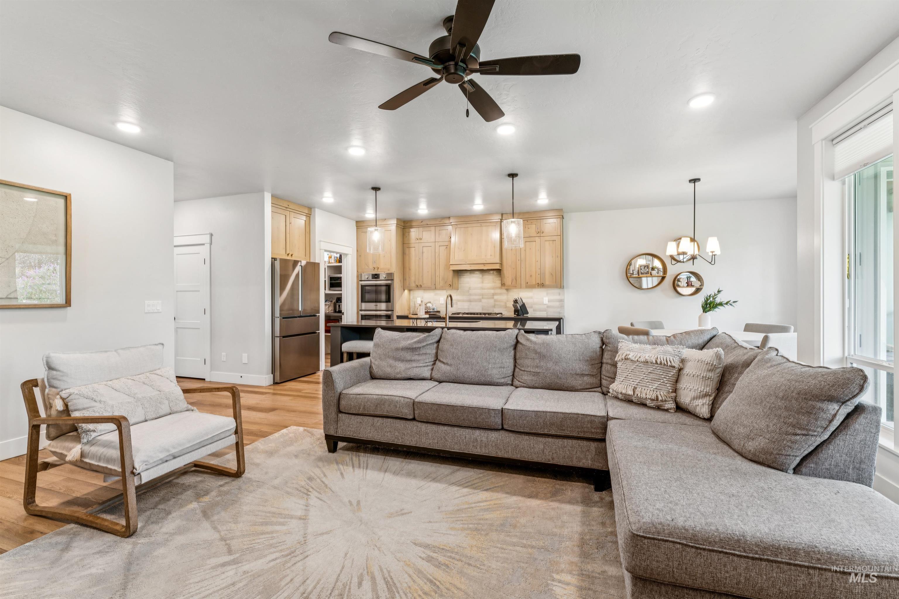 Living area featuring a ceiling fan, a chandelier, recessed lighting, and light wood finished floors