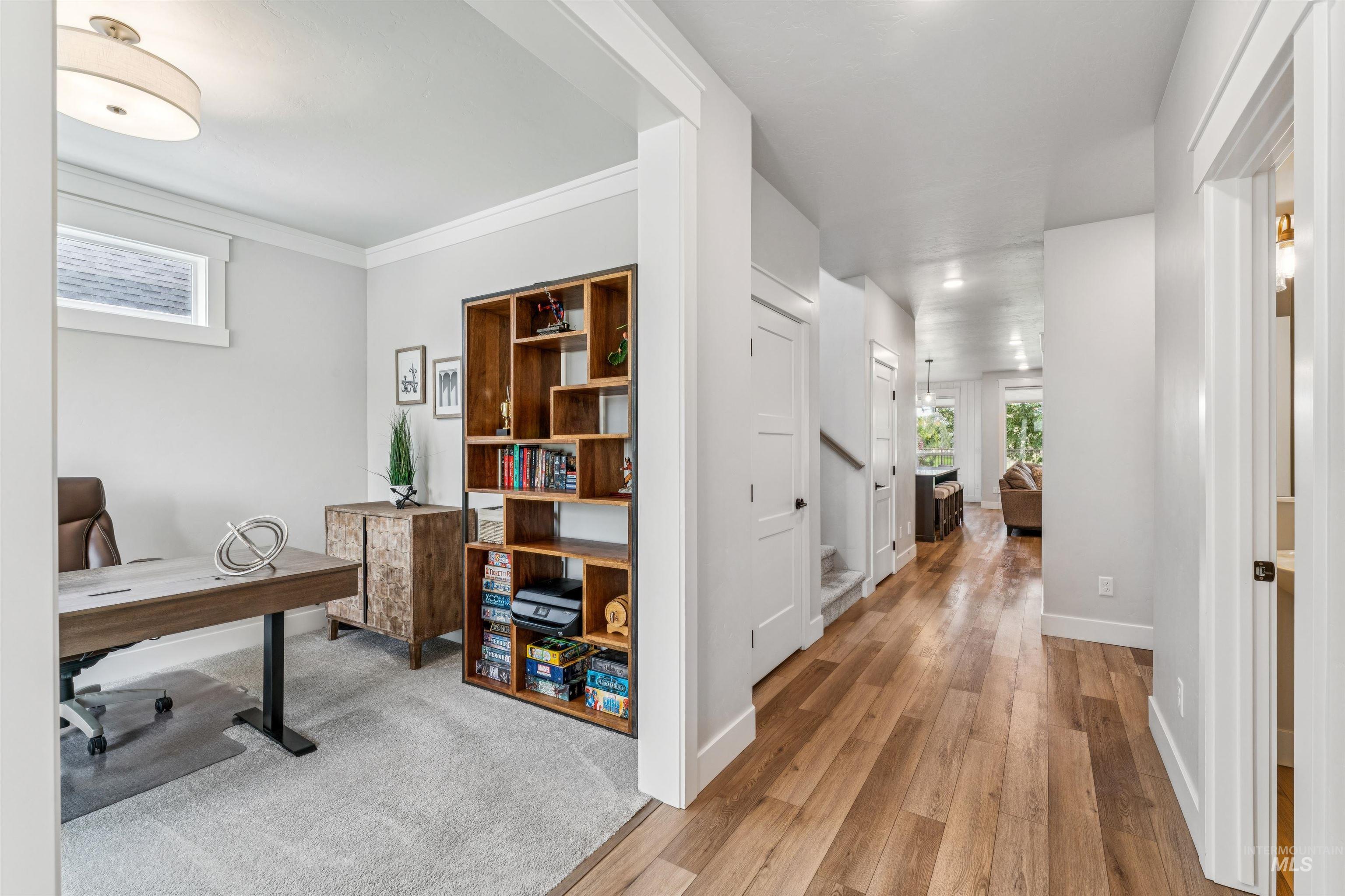 Office with light wood finished floors and ornamental molding